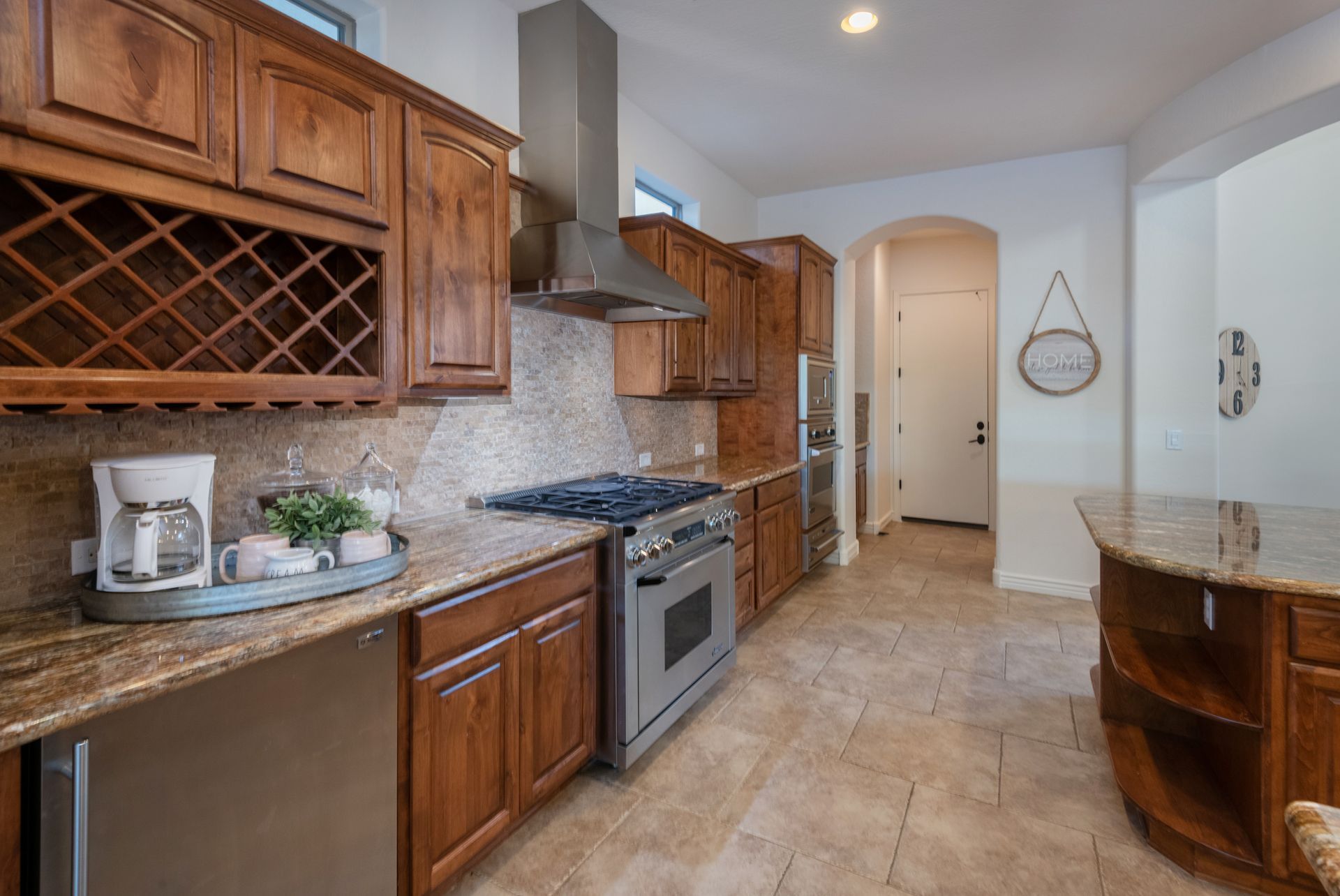 A kitchen with stainless steel appliances and wooden cabinets.