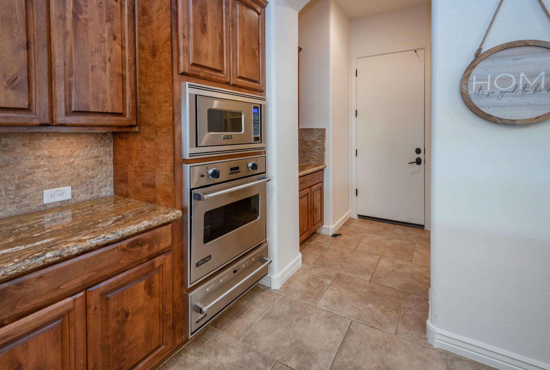A kitchen with stainless steel appliances and wooden cabinets.