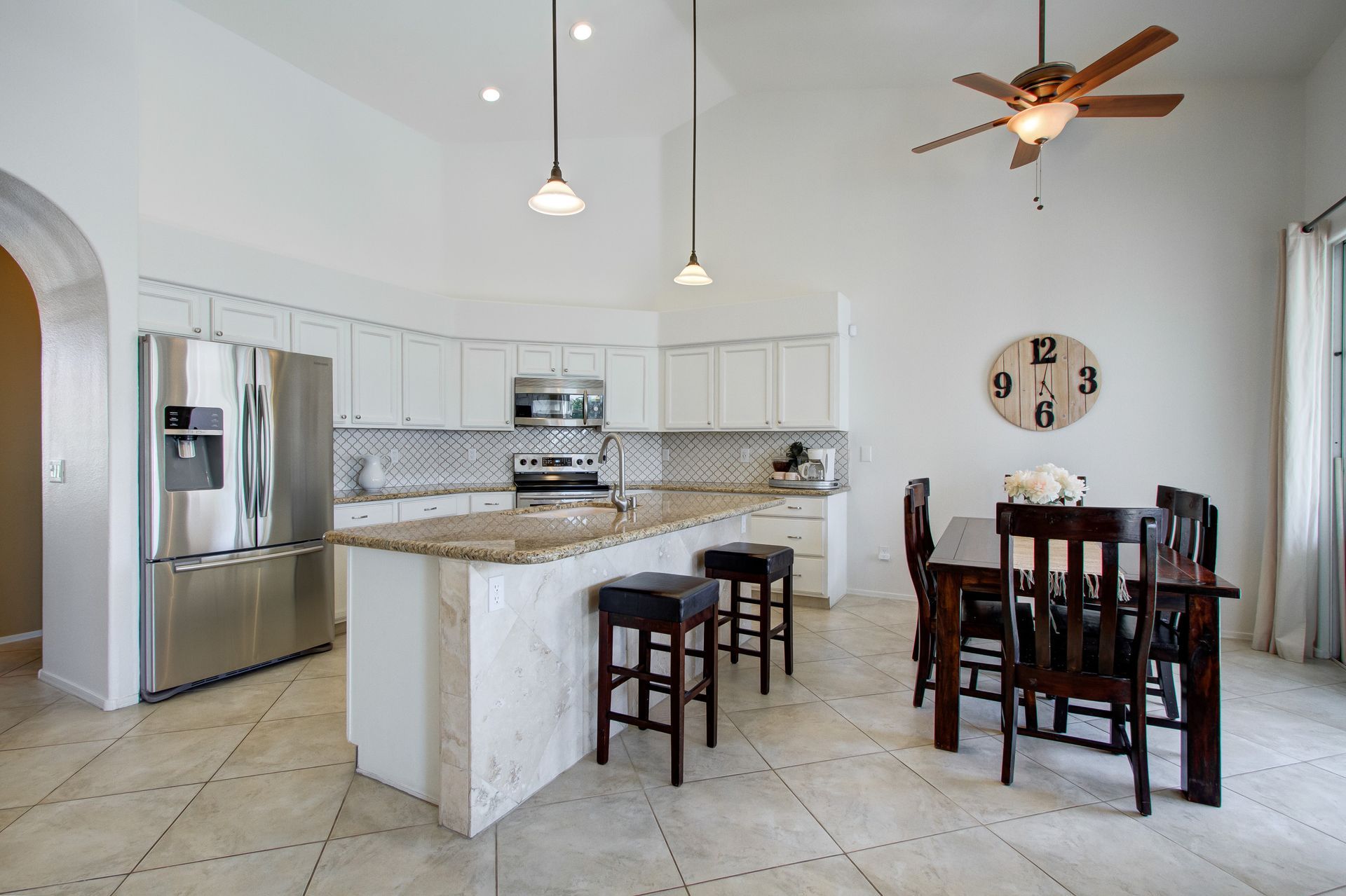 A kitchen with a table and chairs and a ceiling fan