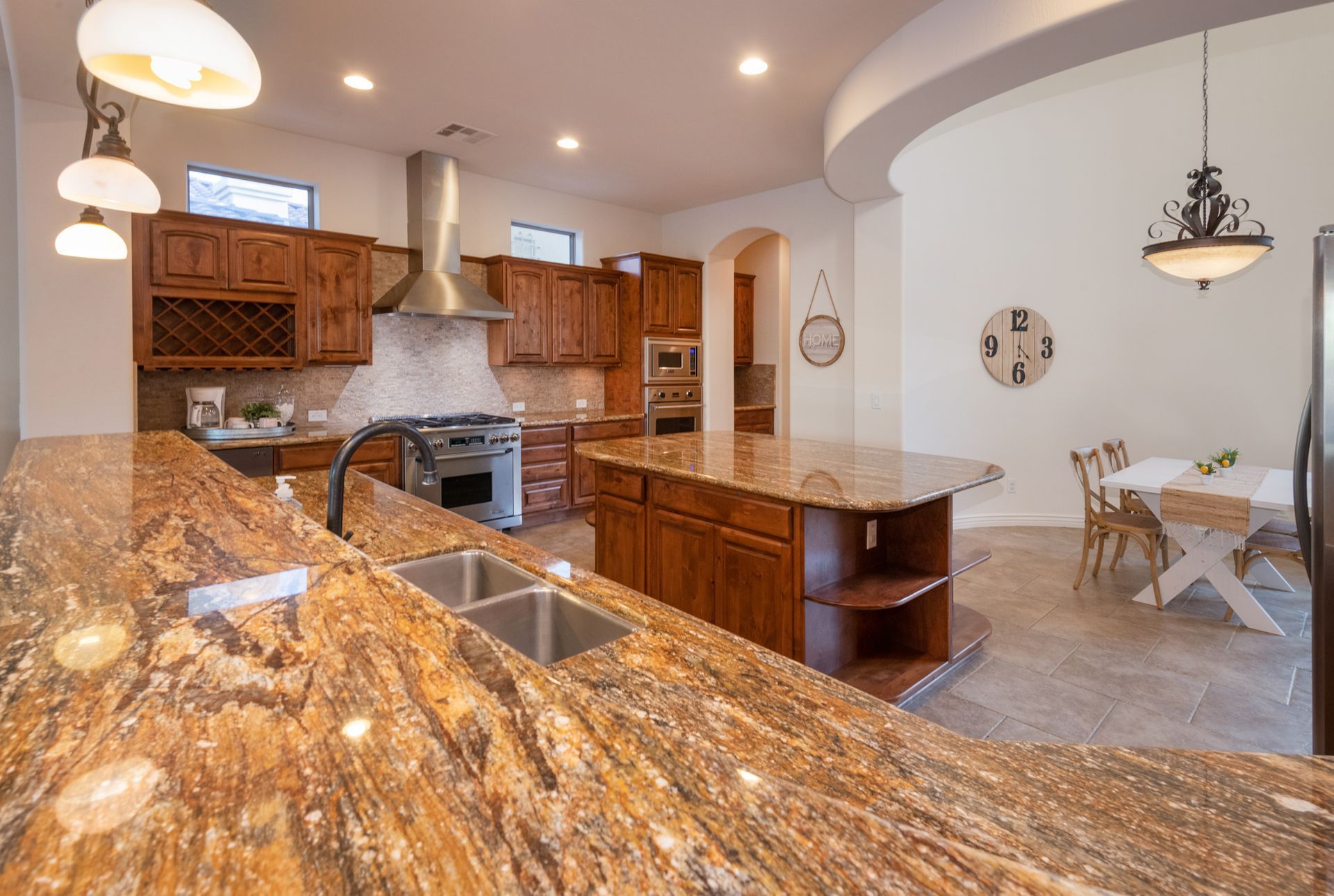A kitchen with granite counter tops , stainless steel appliances , and wooden cabinets.