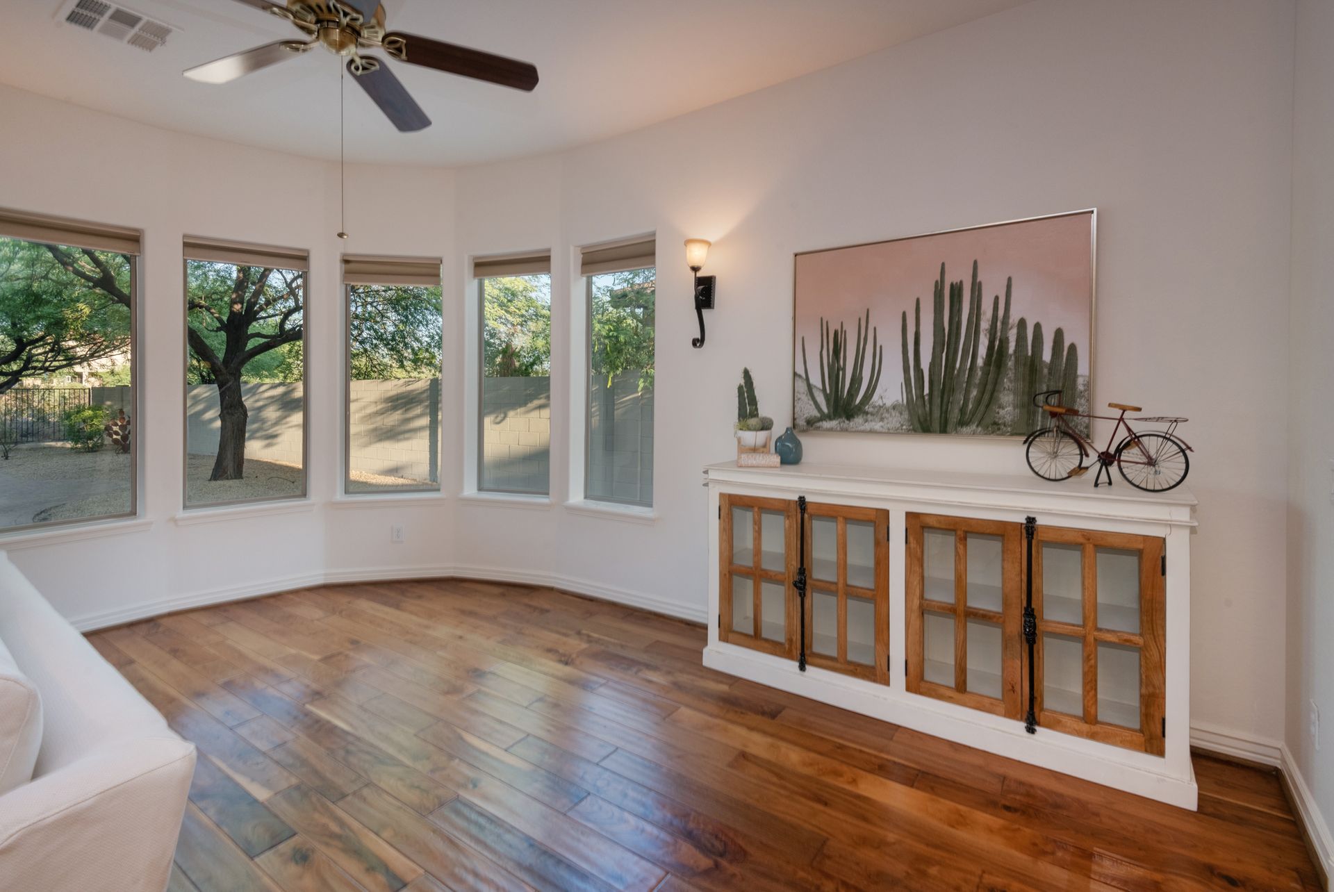 A living room with hardwood floors and a ceiling fan