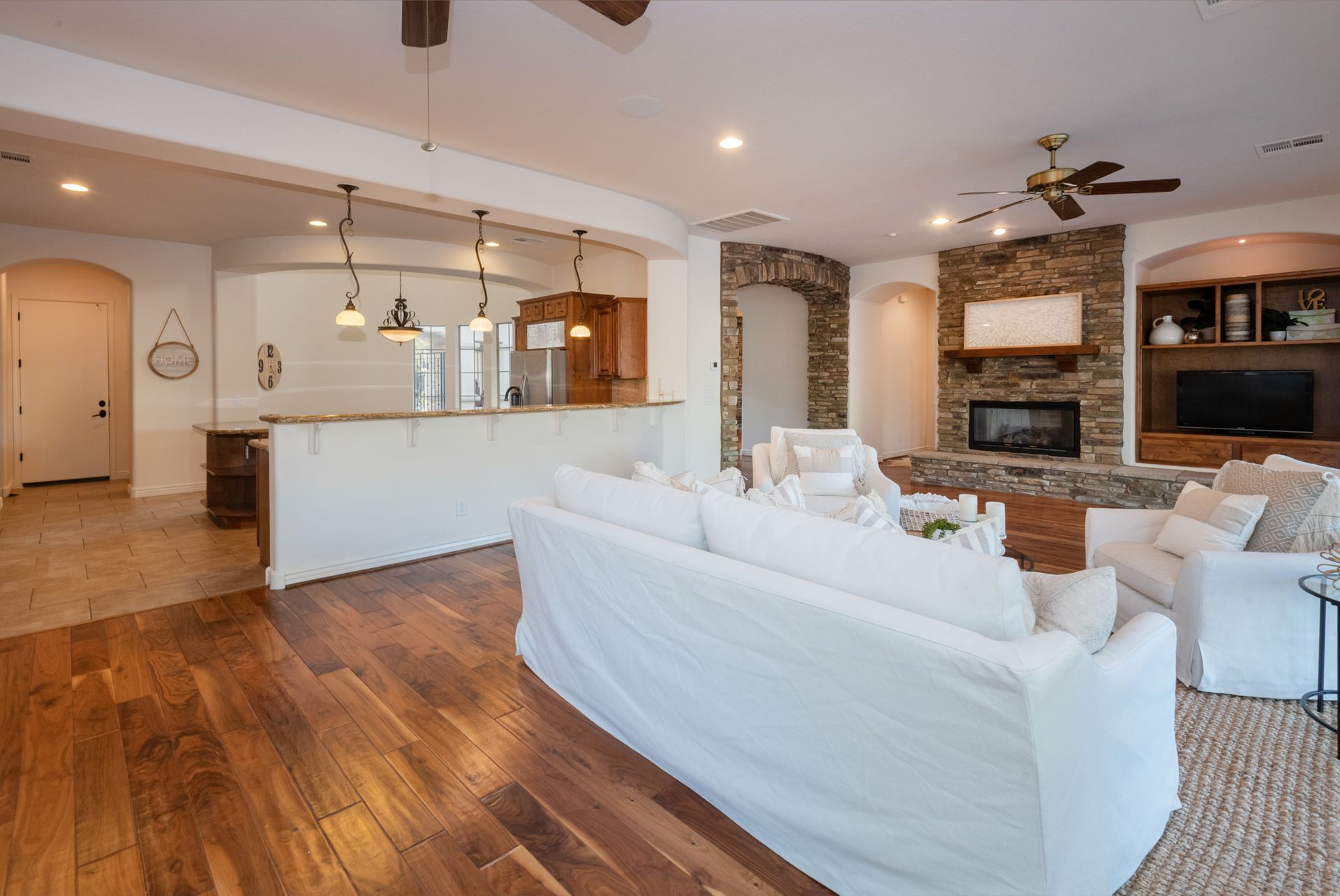 A living room with hardwood floors and a white couch.