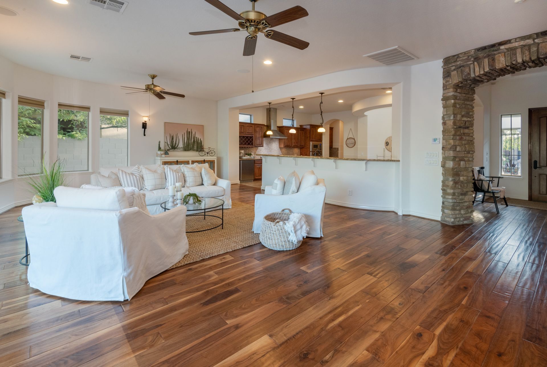 A living room with hardwood floors and a ceiling fan.