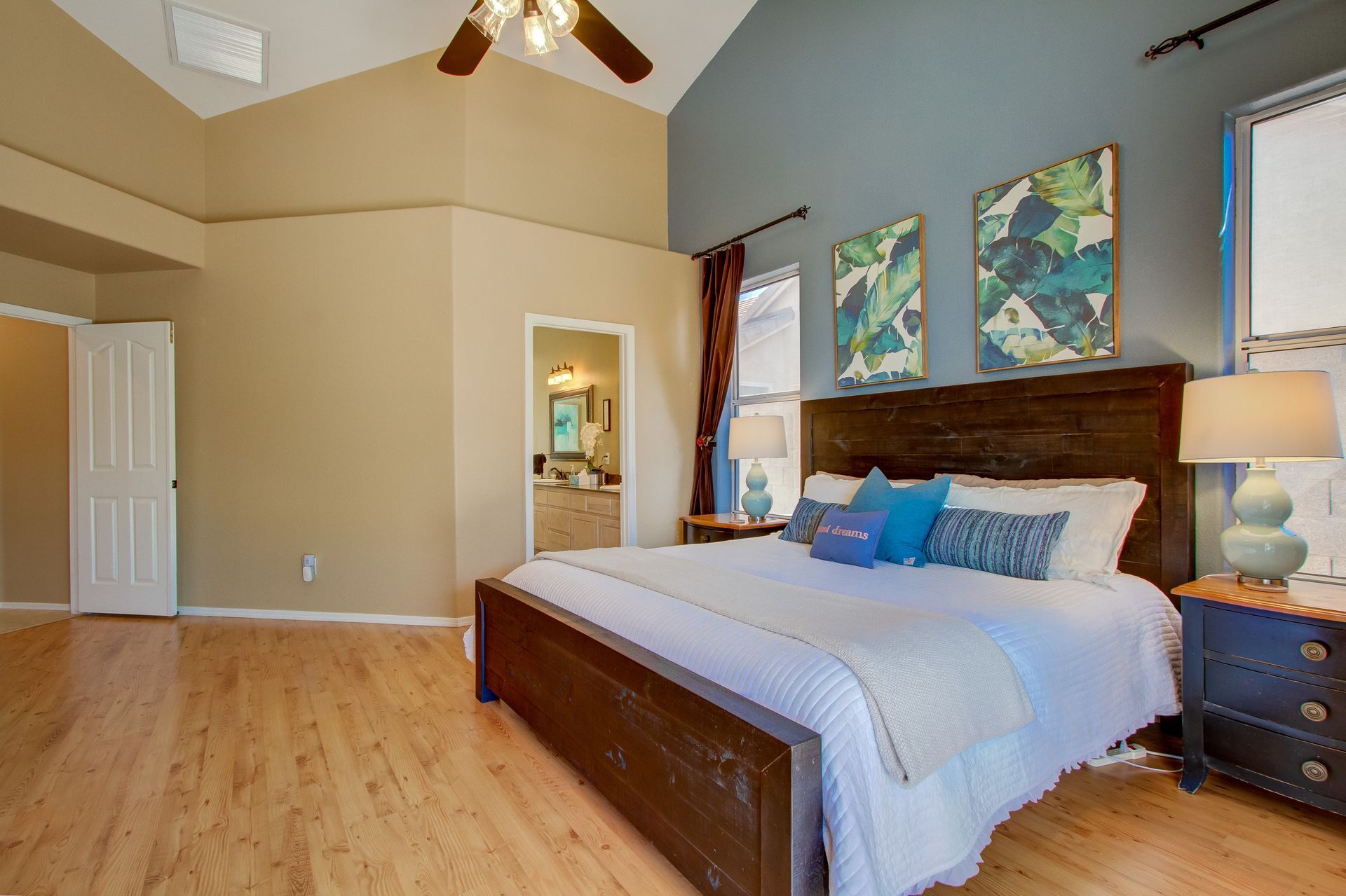 A bedroom with a king size bed and a ceiling fan.
