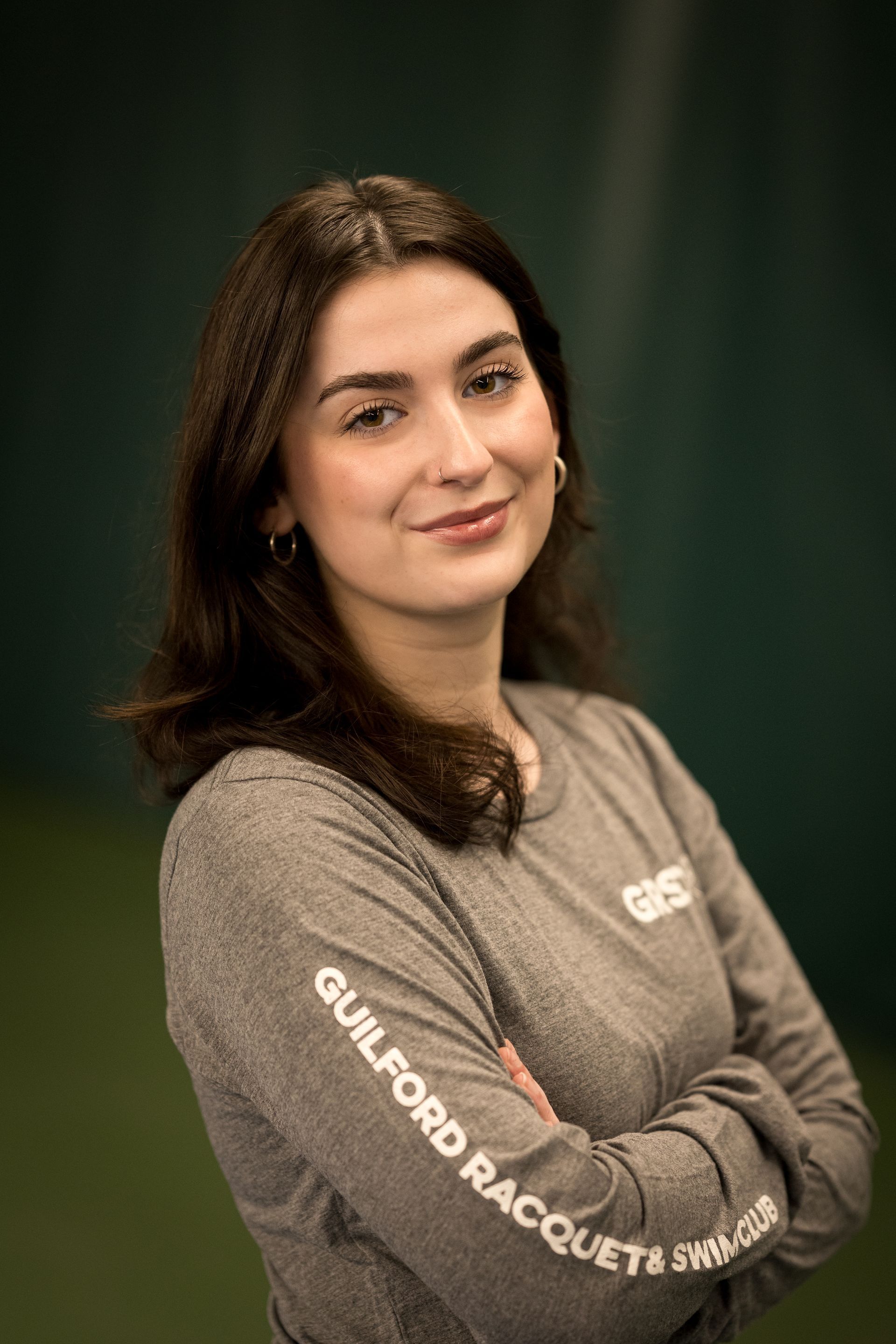 A woman with long brown hair is smiling for the camera.