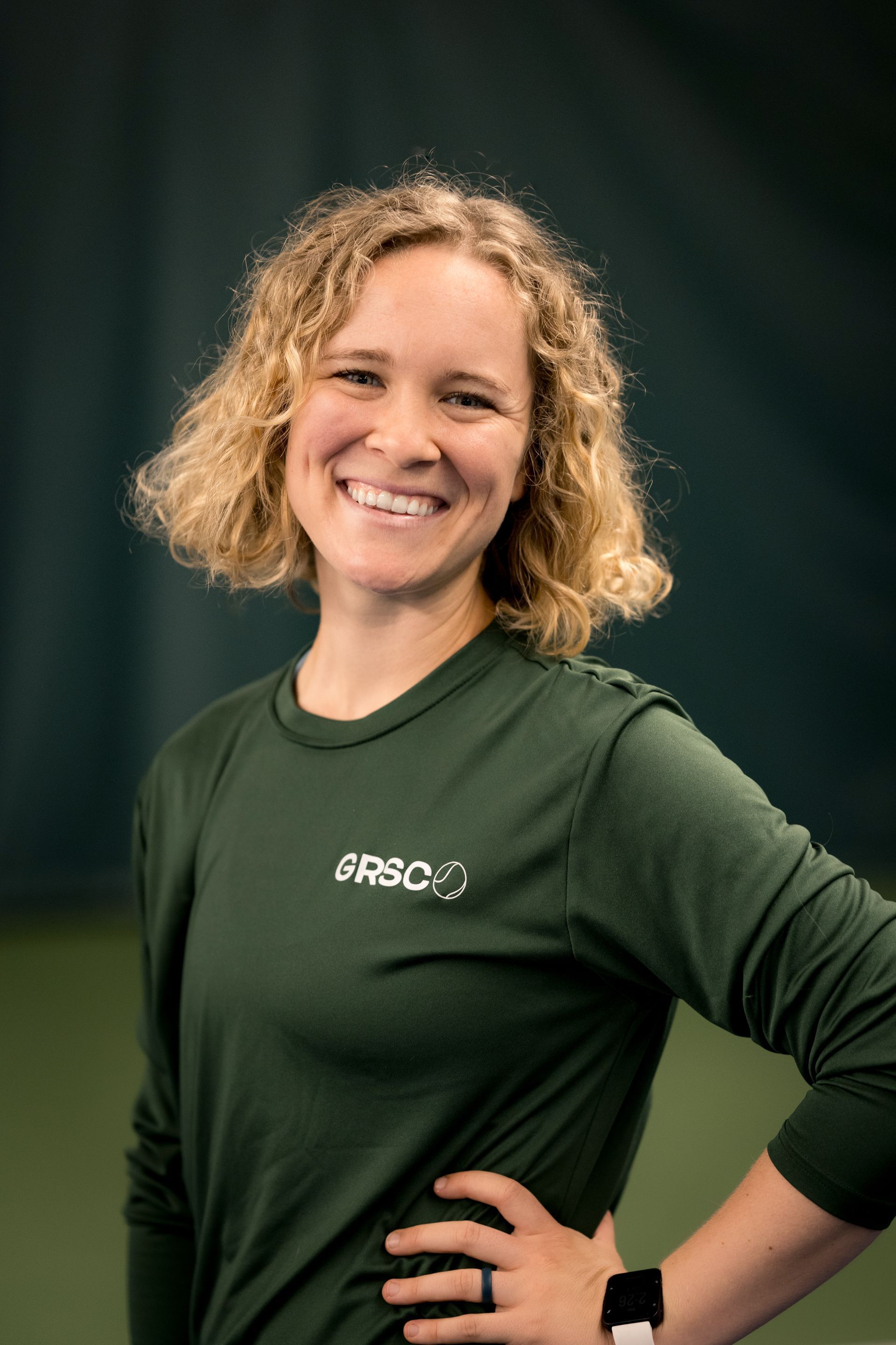A woman with long brown hair is smiling for the camera.