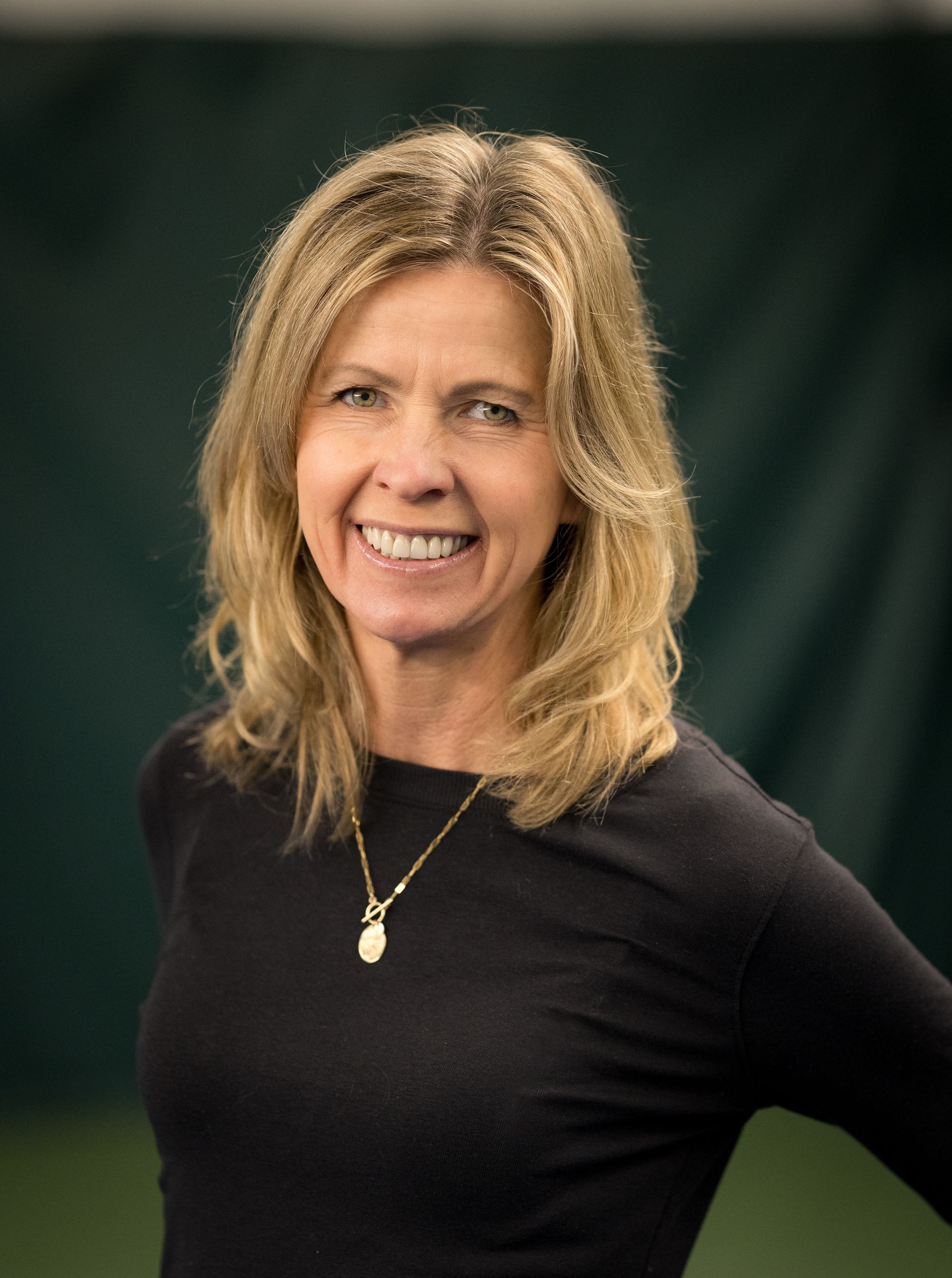 A man with his arms crossed is wearing a gray shirt