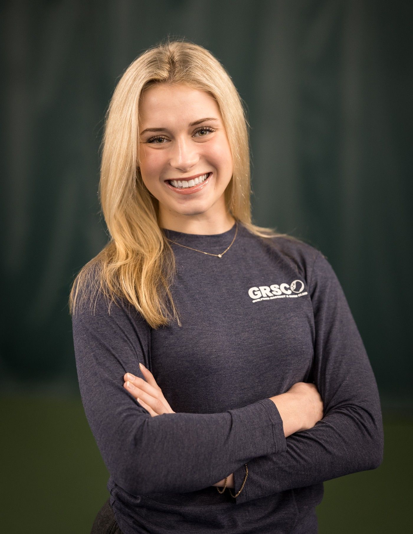 A woman with long brown hair is smiling for the camera.