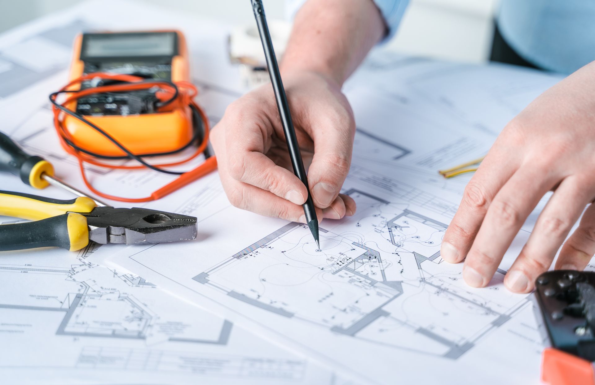 A person is drawing a house plan on a piece of paper.