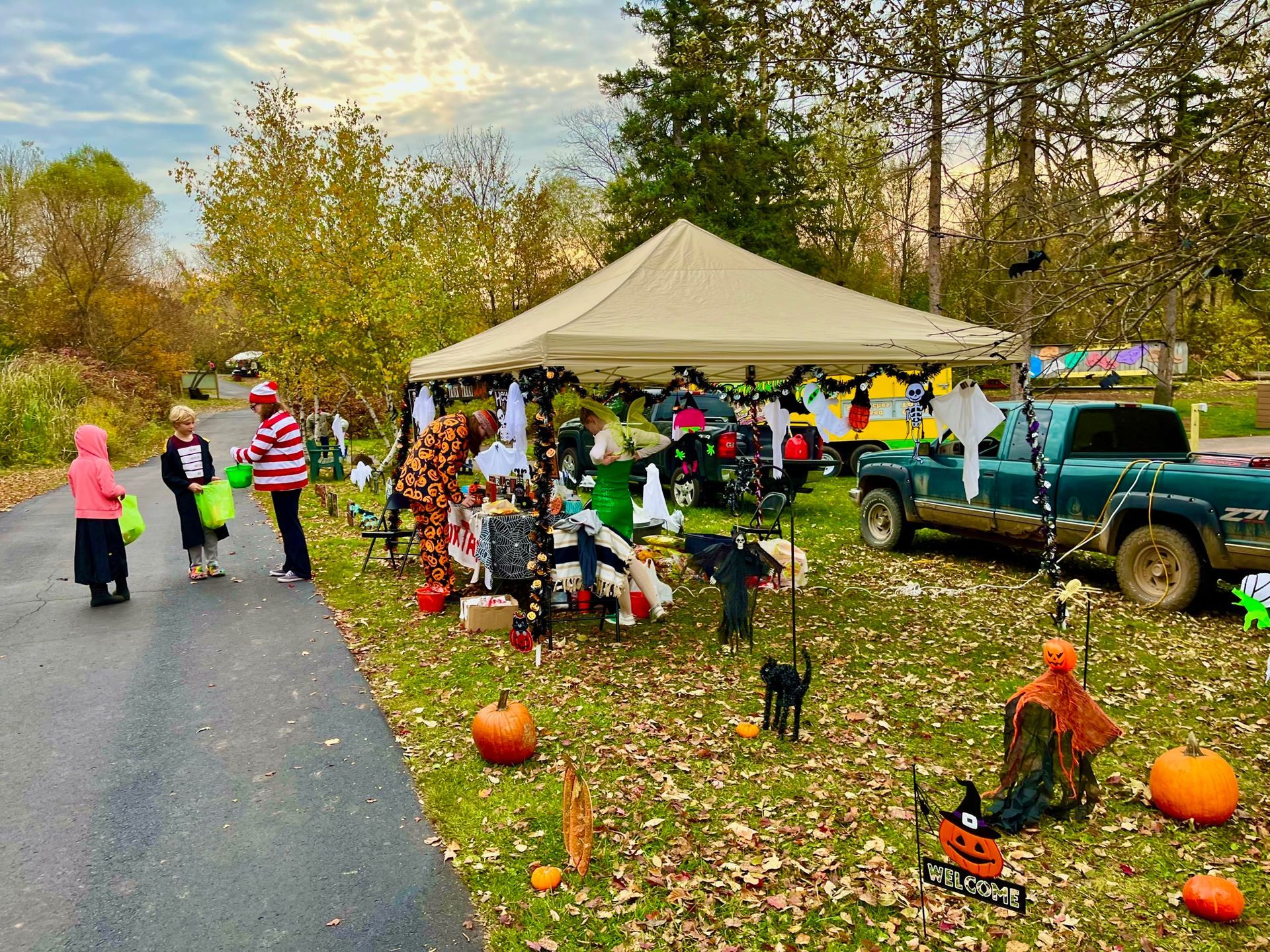 A group of people are walking down a road next to a truck.