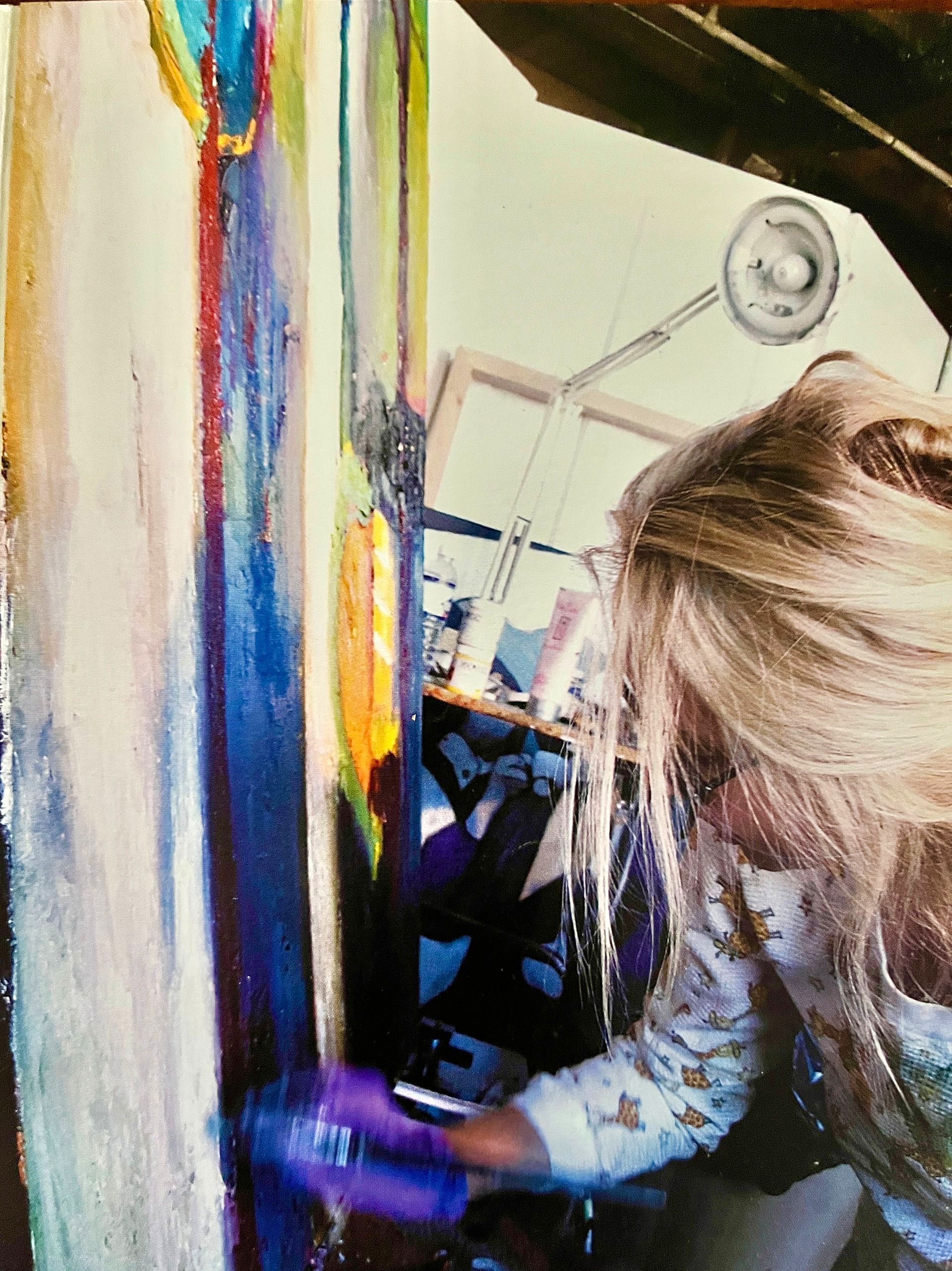 A woman is holding a child in front of a large ship