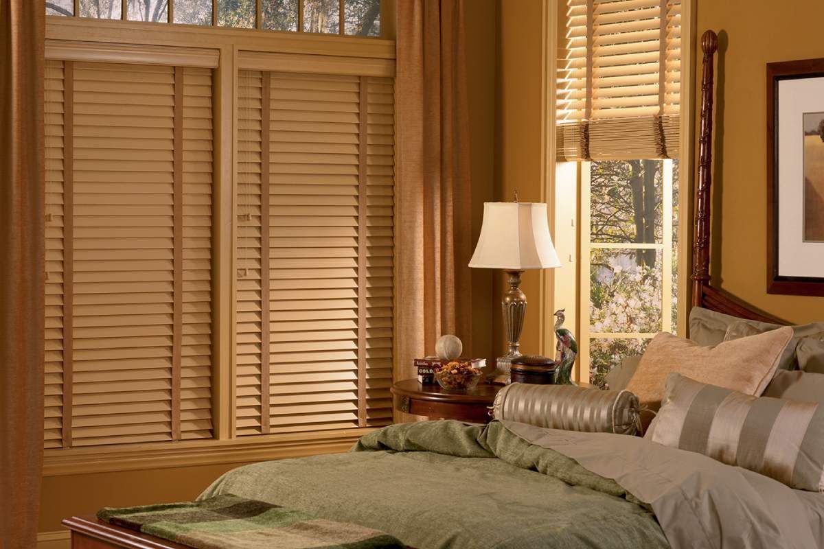 Hunter Douglas Modern Precious Metals® Mini Blinds in a bedroom filtering sunlight from multiple windows.