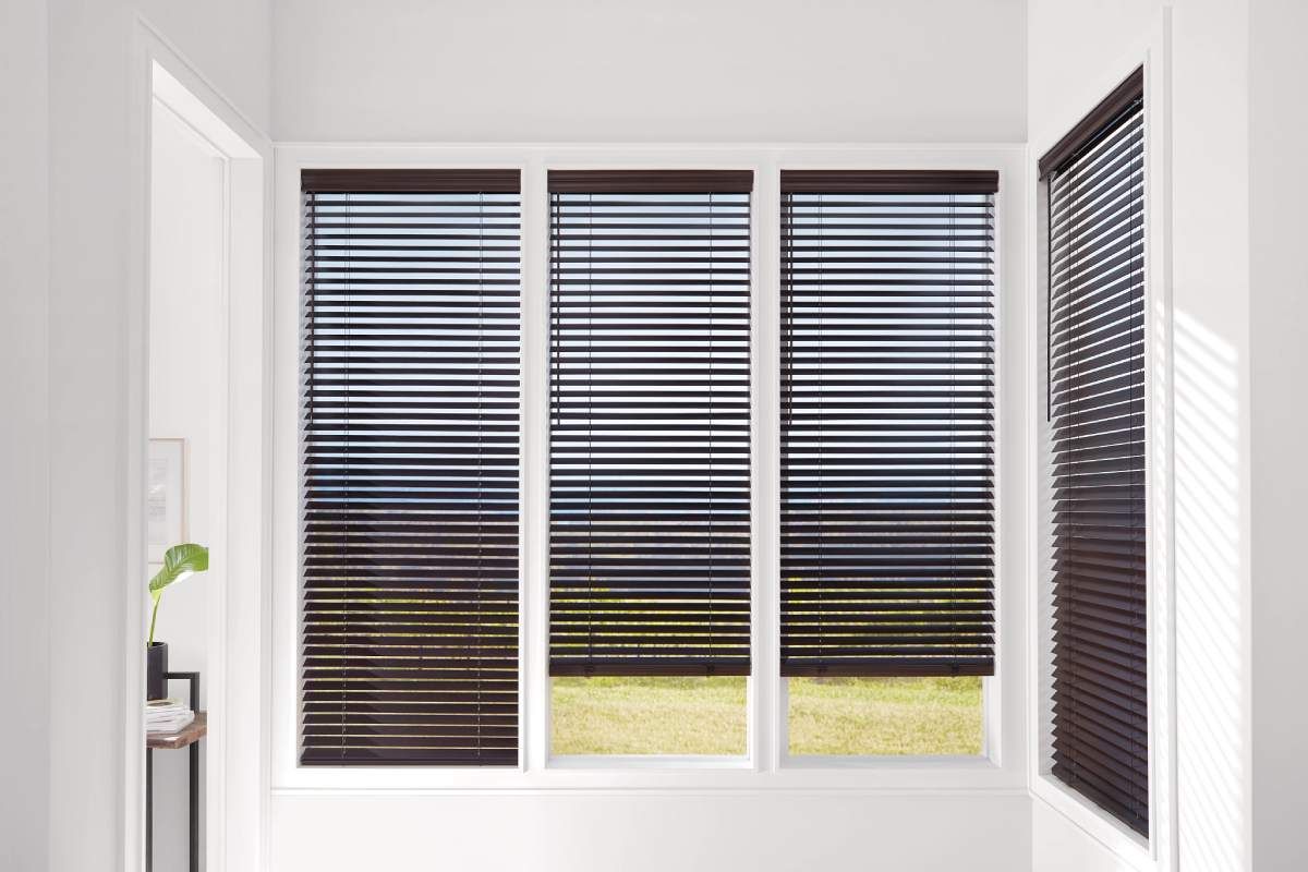 Hunter Douglas Parkland® Wood Blinds framed by stark white windowsills.