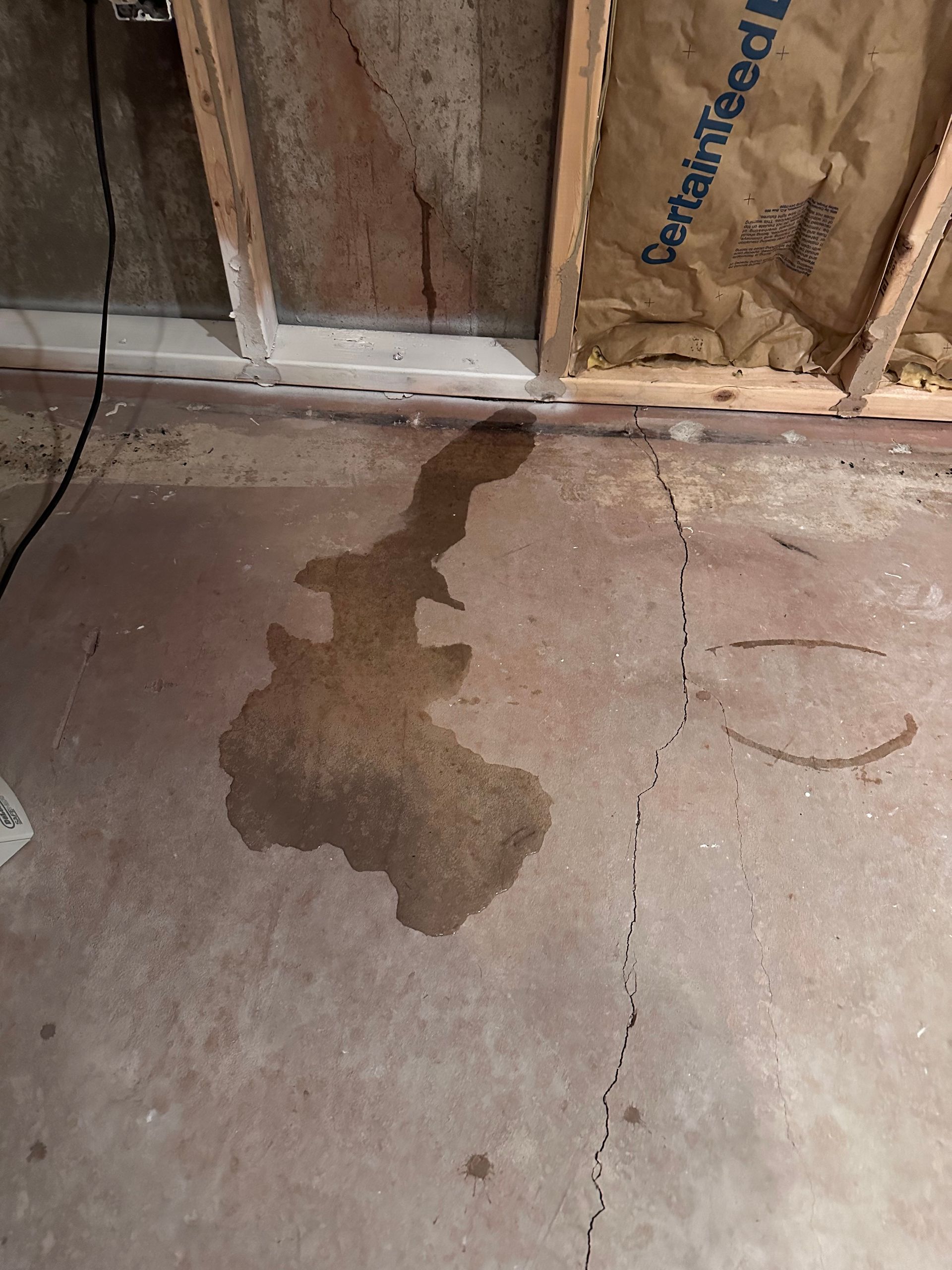 A puddle of water is on the floor of a room.