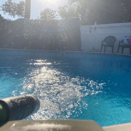 A person is spraying water into a swimming pool