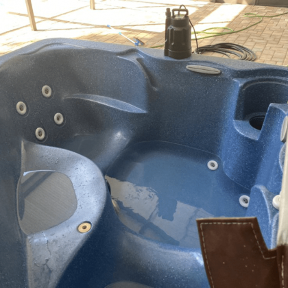 A blue hot tub with a pump on top of it
