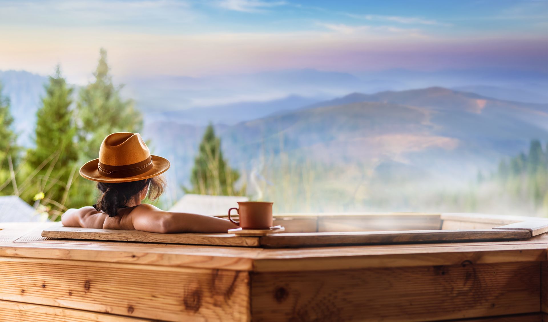 Young woman in an open air bath with view of the mountains