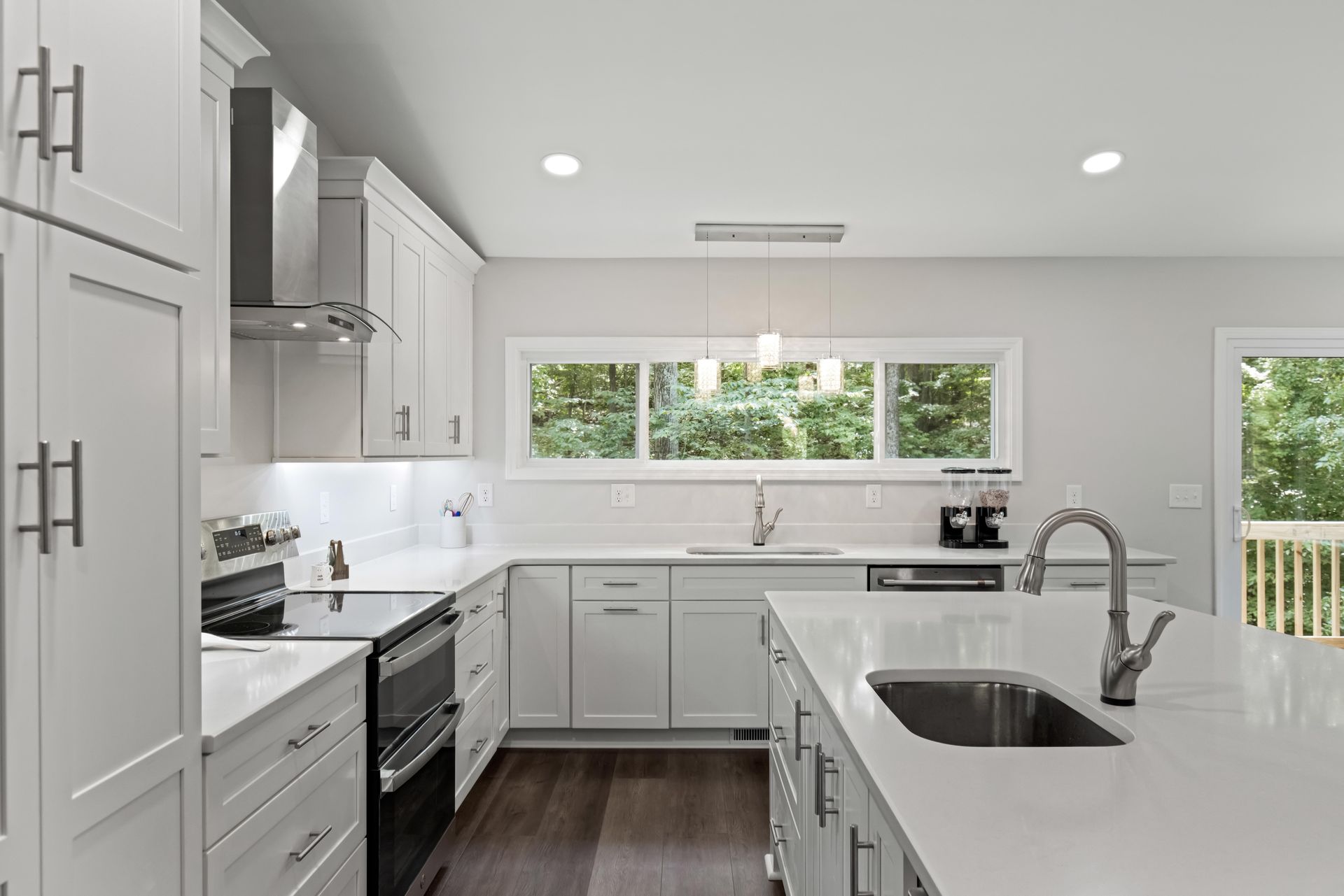 A kitchen with white cabinets , stainless steel appliances , and a sink.