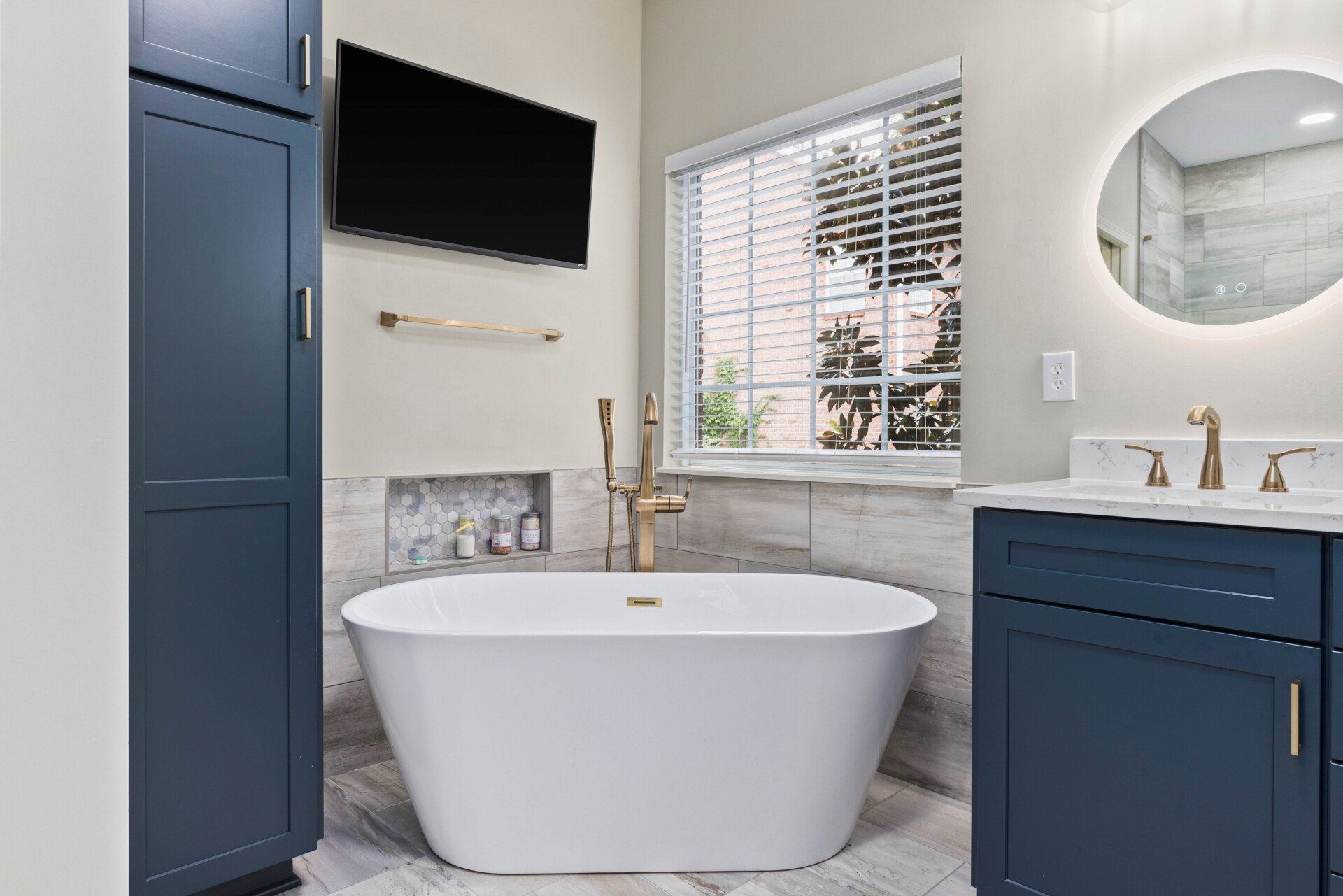 A bathroom with a bathtub , sink , and television.