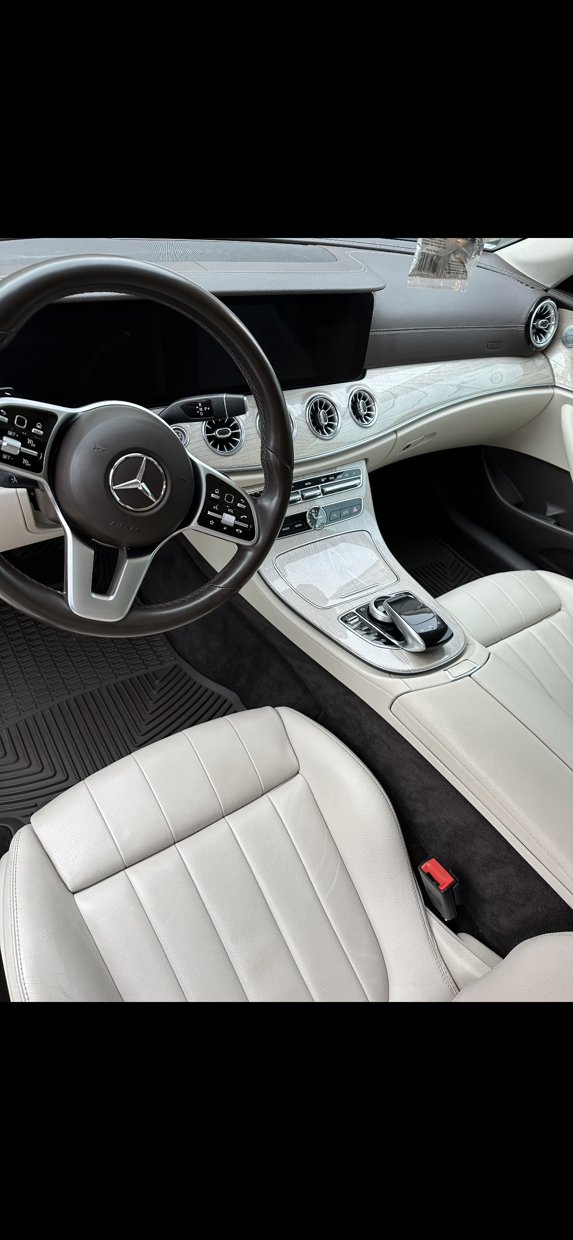 The interior of a car with a steering wheel and seats.