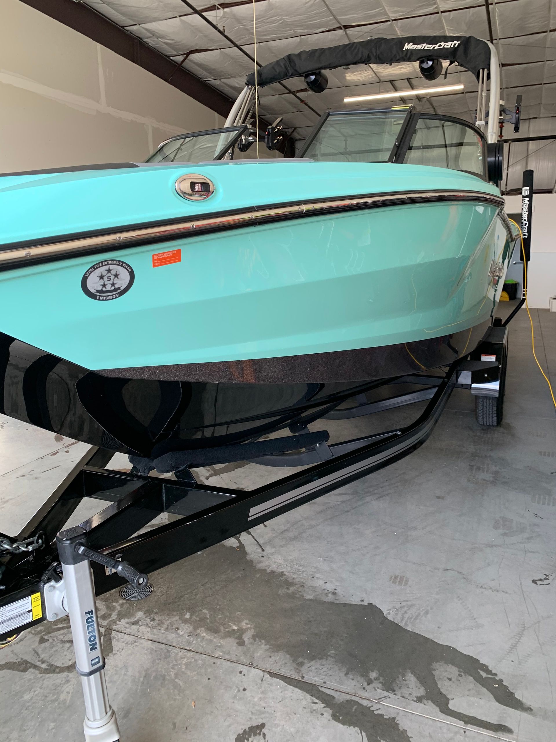 A boat is sitting on a trailer in a garage.