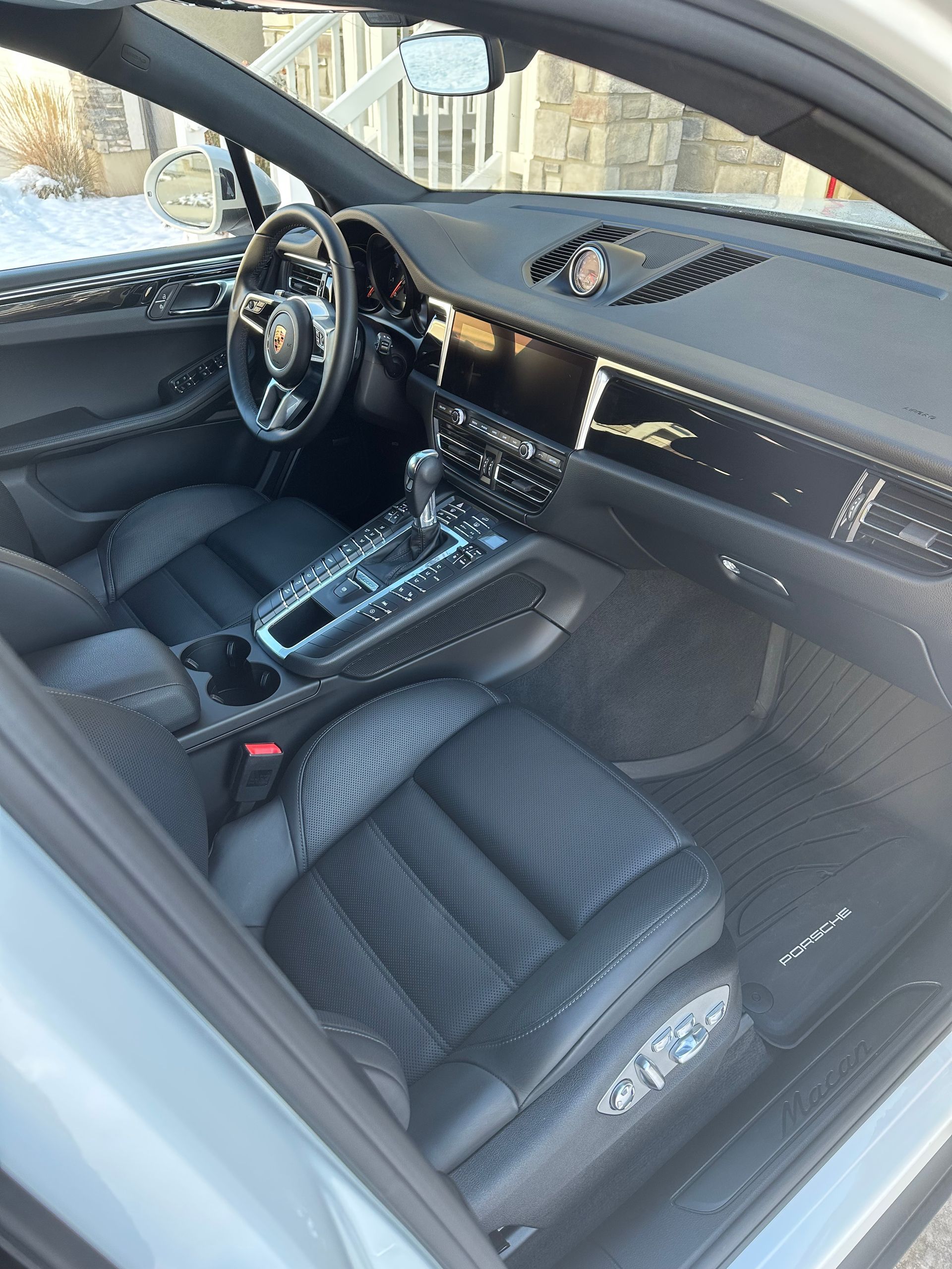 The interior of a porsche macan is shown with the door open