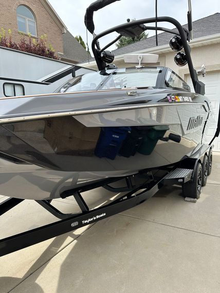 A boat is parked in a driveway next to a house.