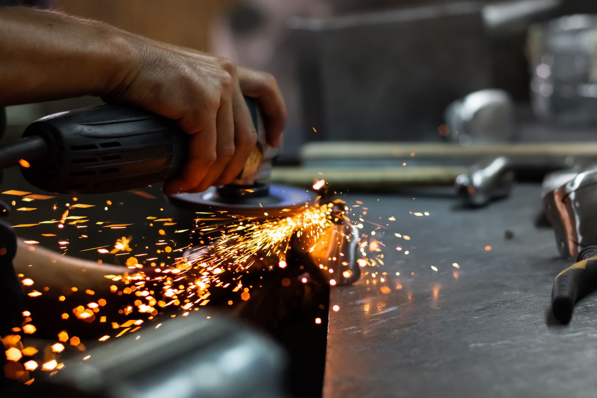 A person is grinding a piece of metal with a grinder.