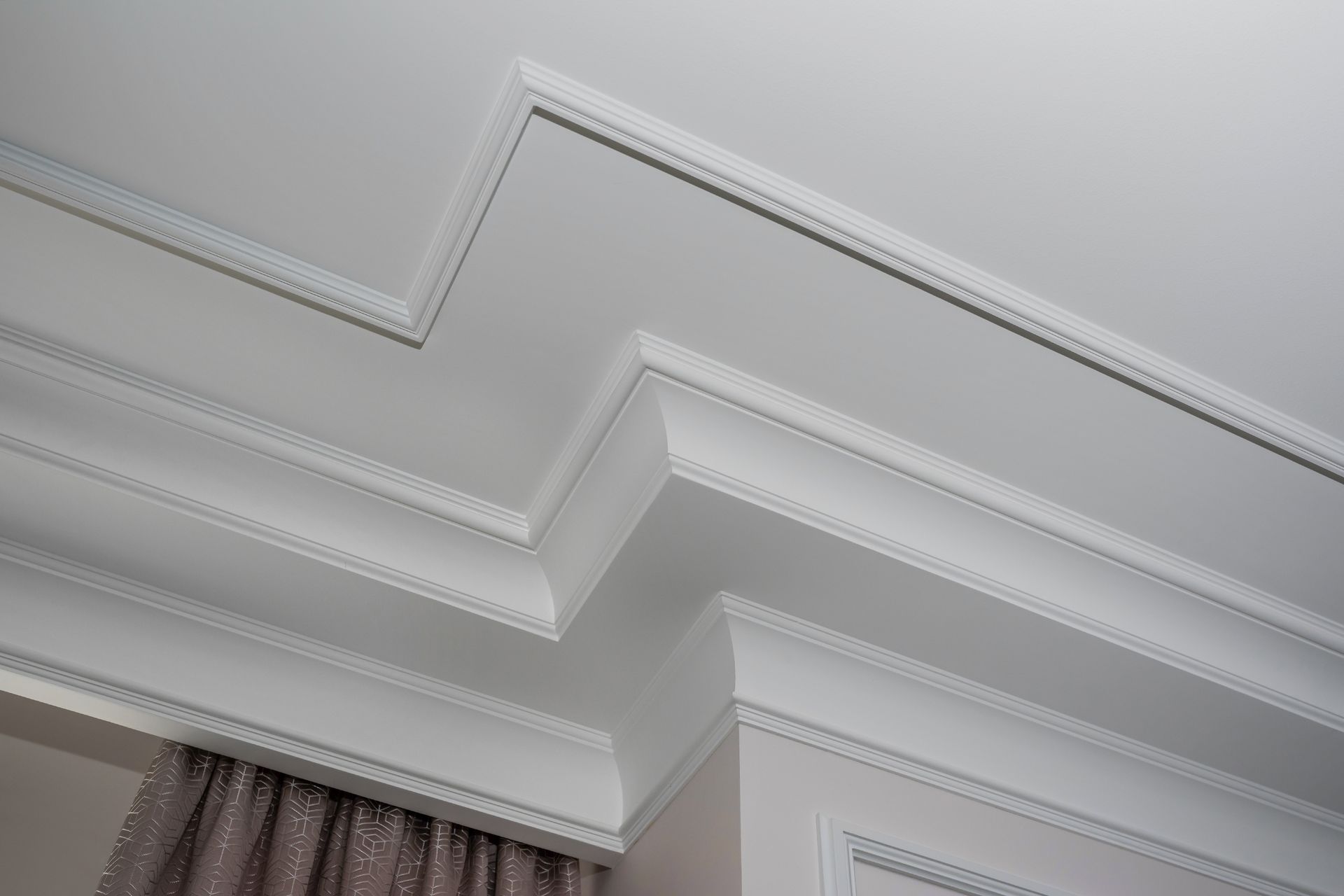 There are many different types of molding on the ceiling in this room.
