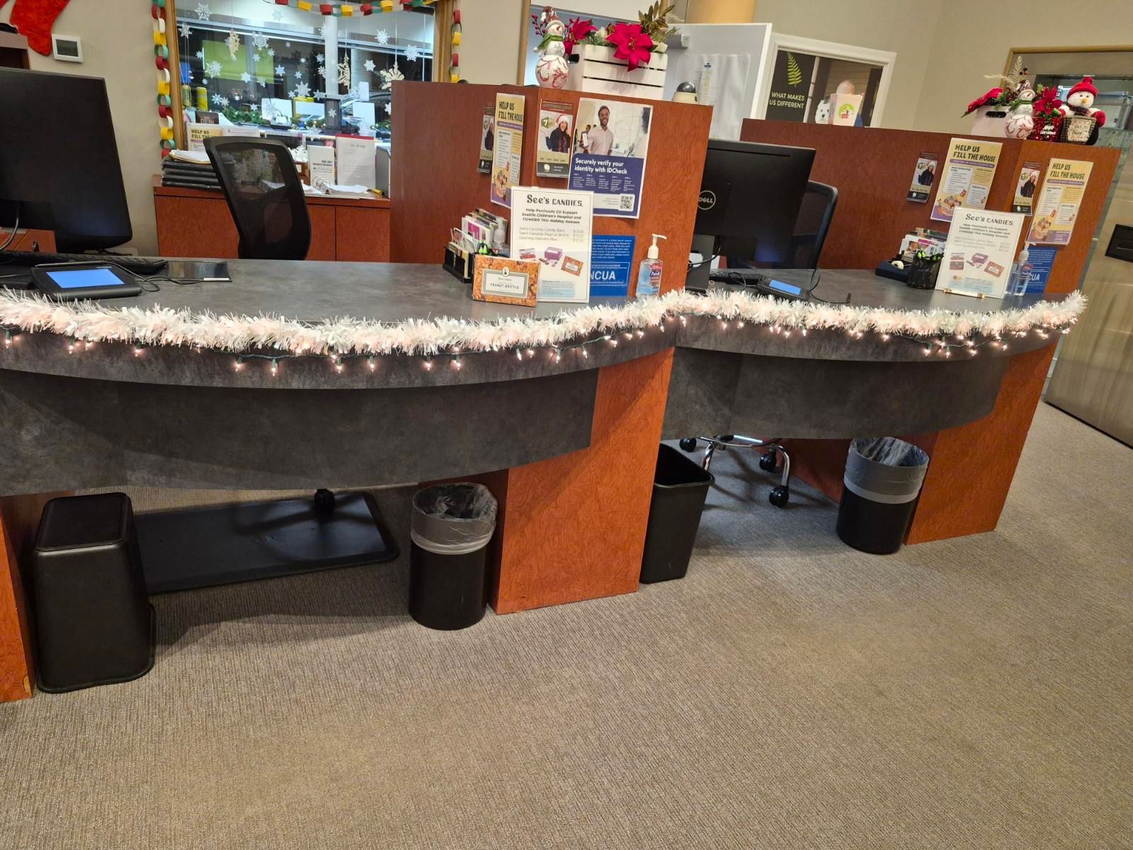 Two office desks with decorations, a computer, and trash cans.