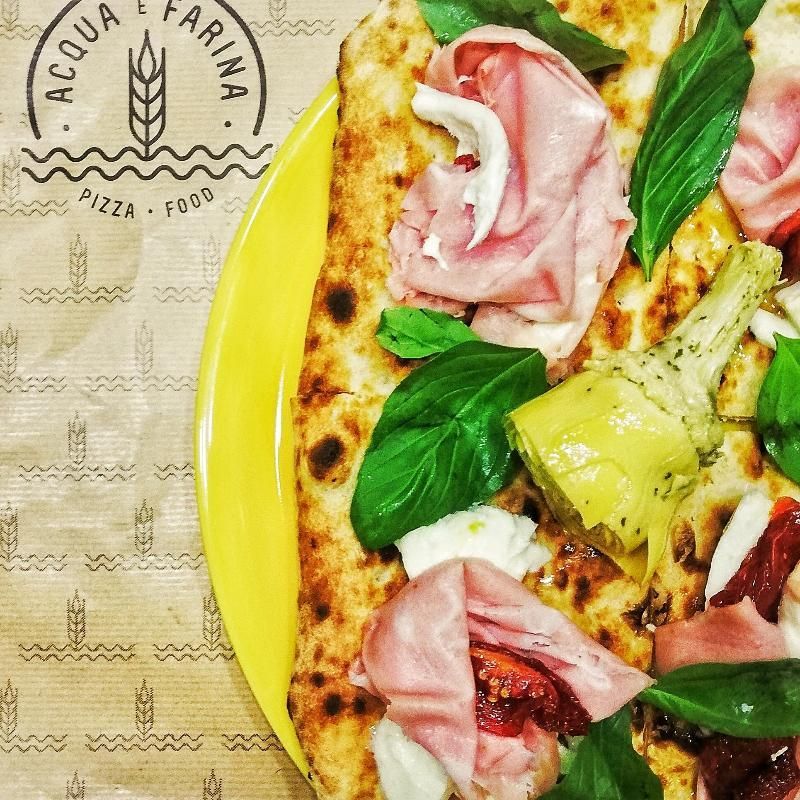 Una pizza su un piatto giallo con scritto acqua farina