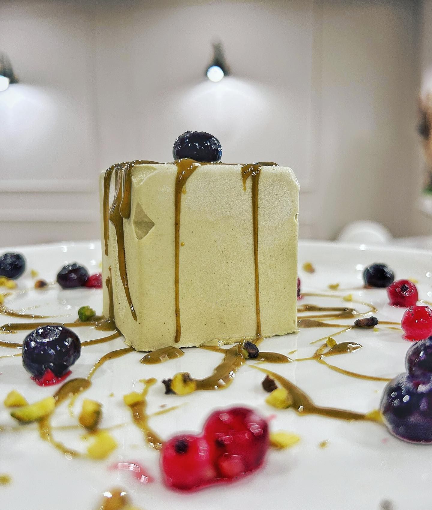 Un piatto bianco sormontato da un pezzo di torta e frutti di bosco