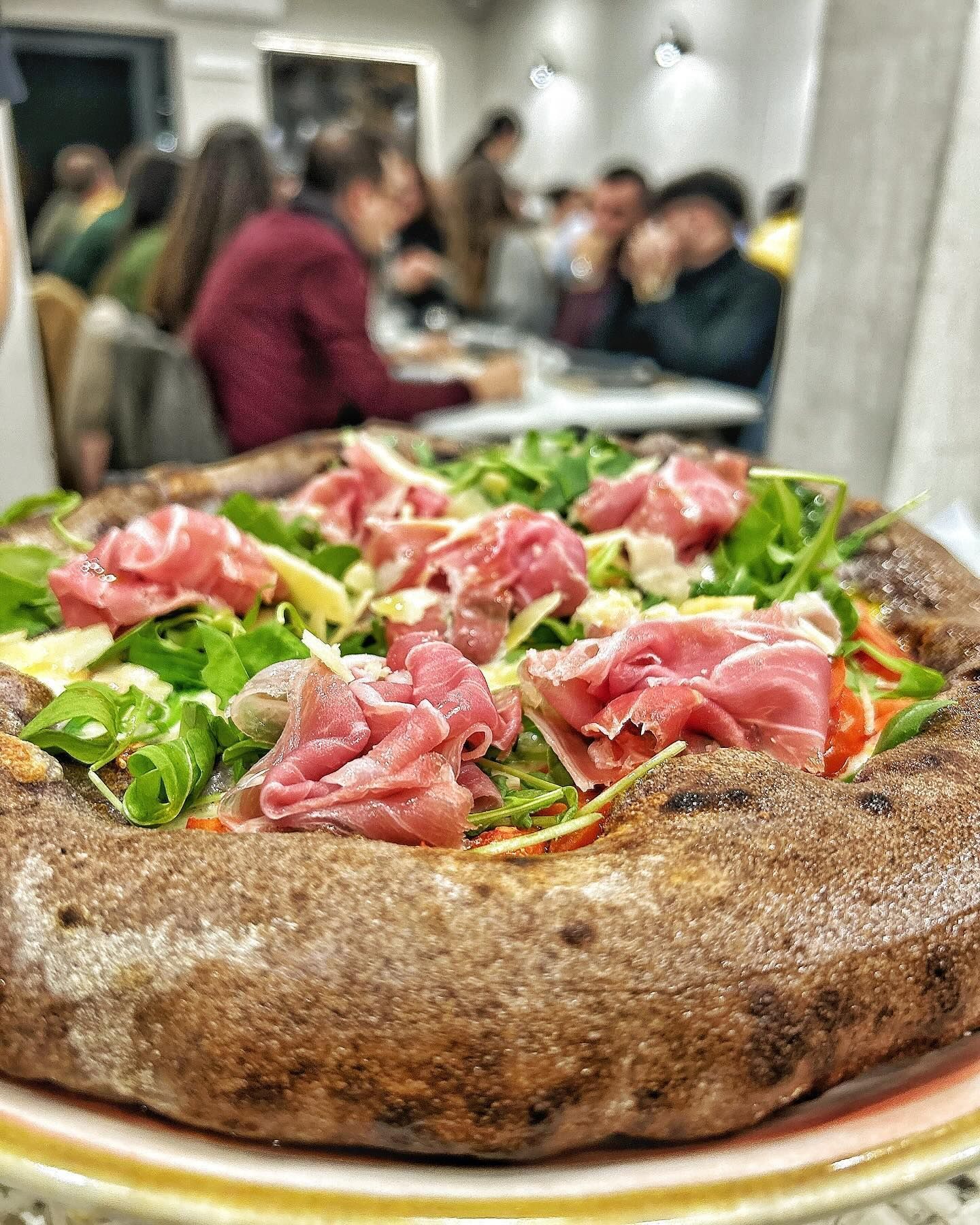 Una pizza con carne e verdure è su un piatto.