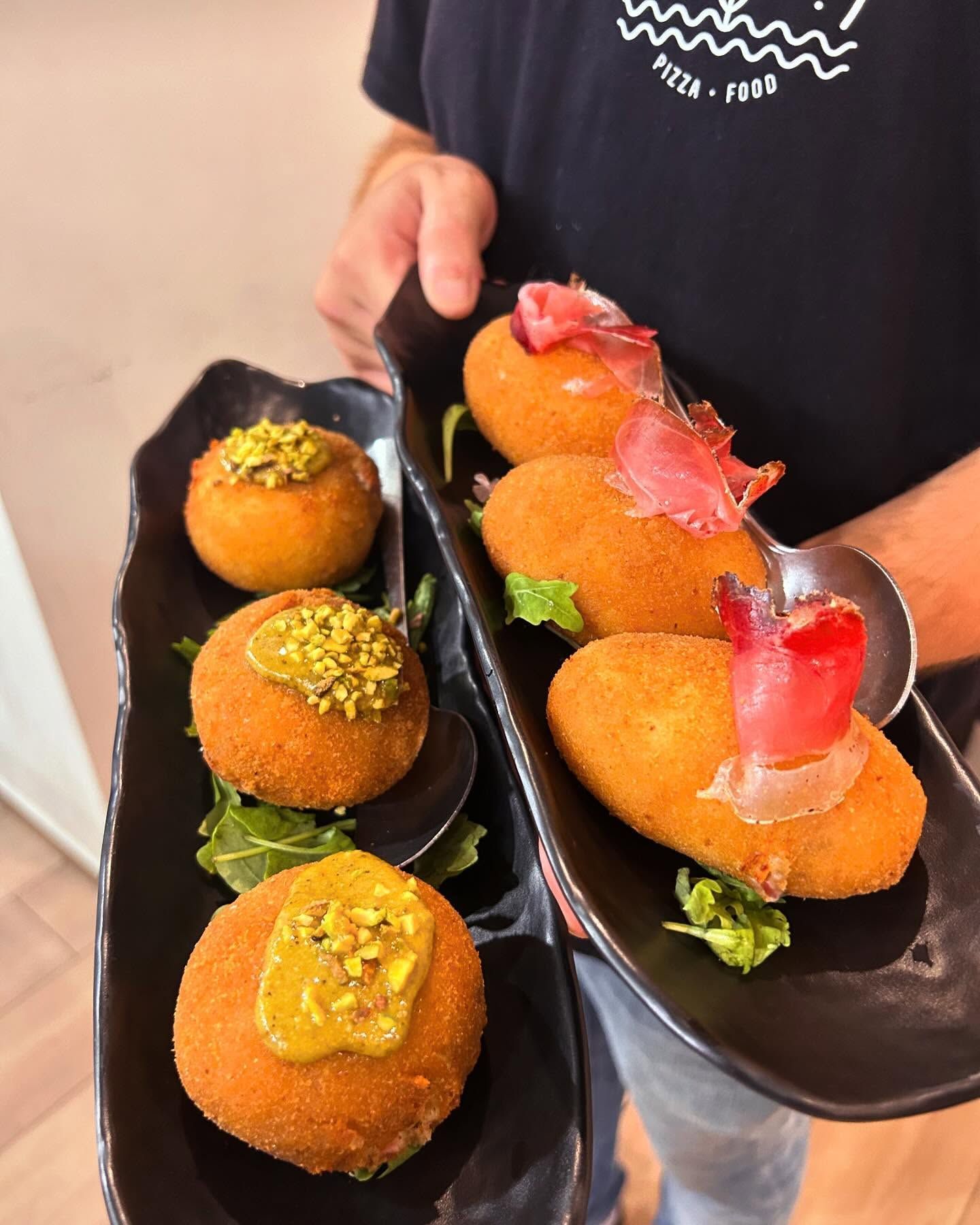 Una persona tiene in mano un vassoio di cibo con un cucchiaio dentro