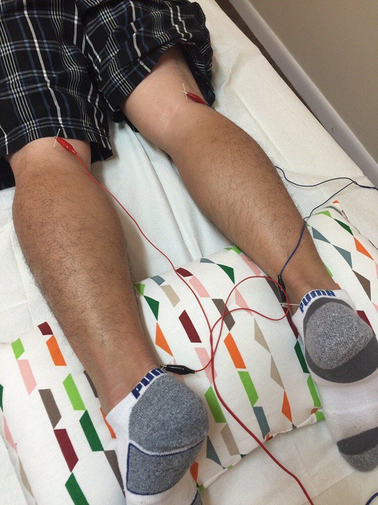 A person laying on a bed with a pair of puma socks on