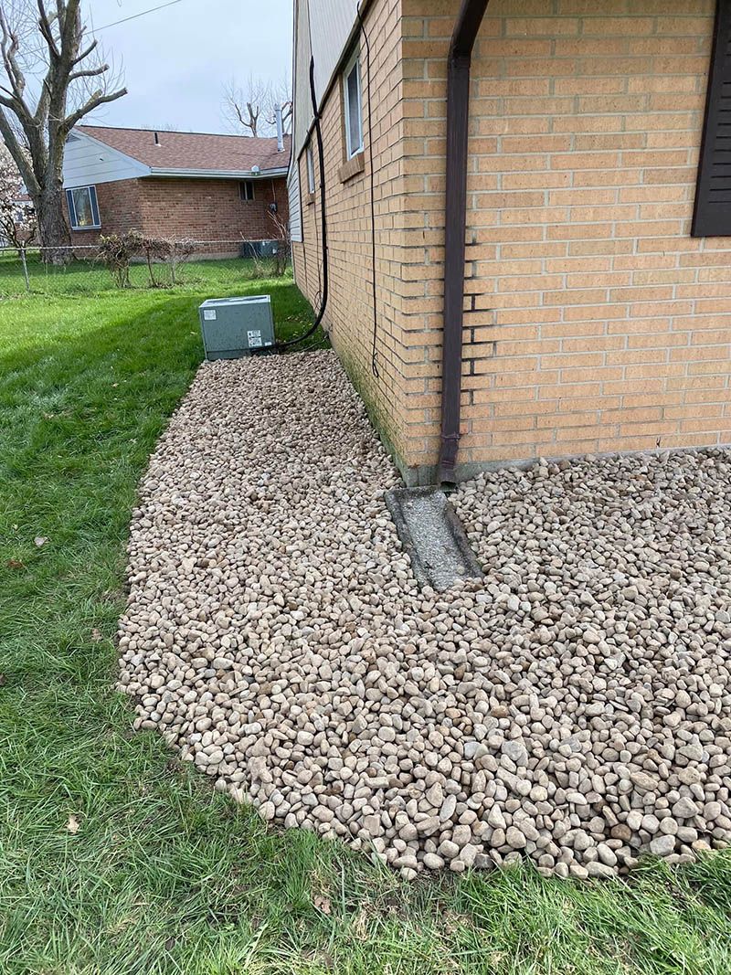 A brick house with a gravel walkway in front of it.