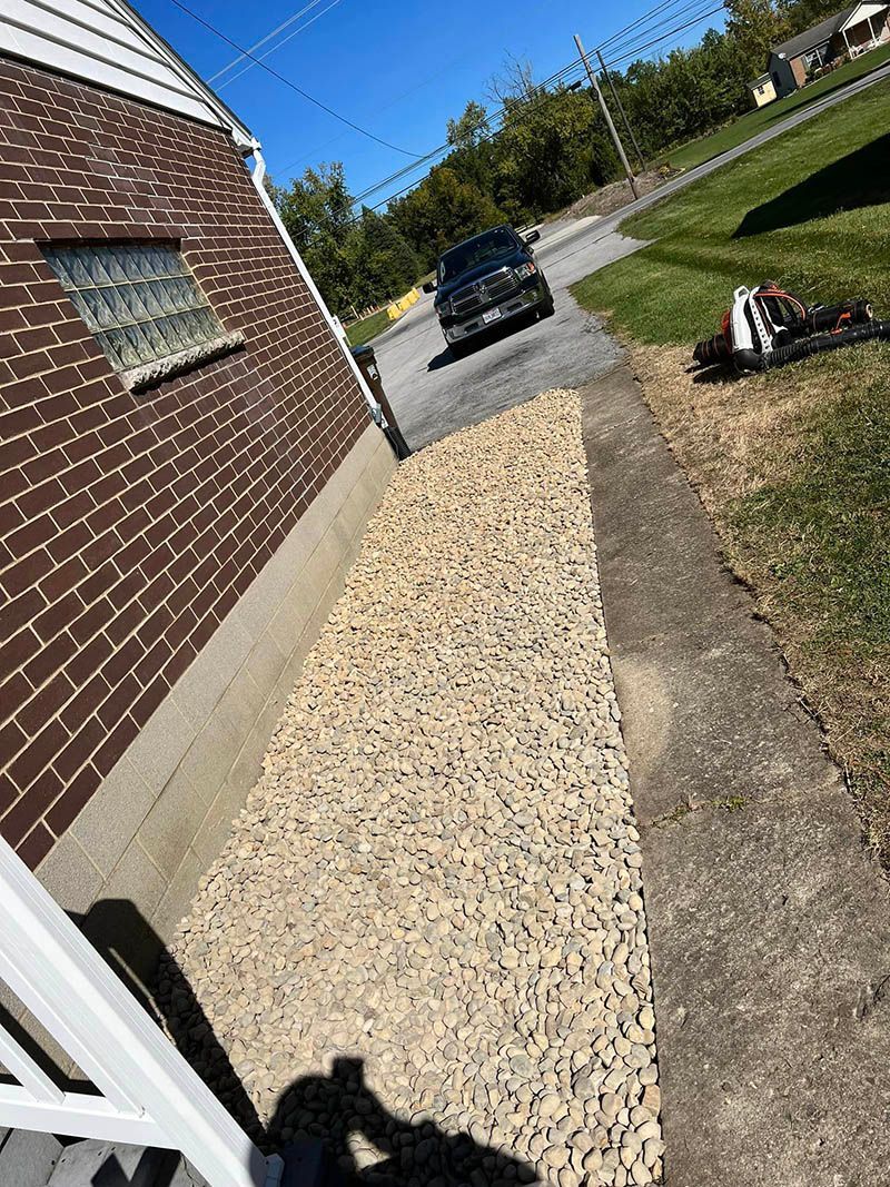 A car is driving down a sidewalk next to a brick building.