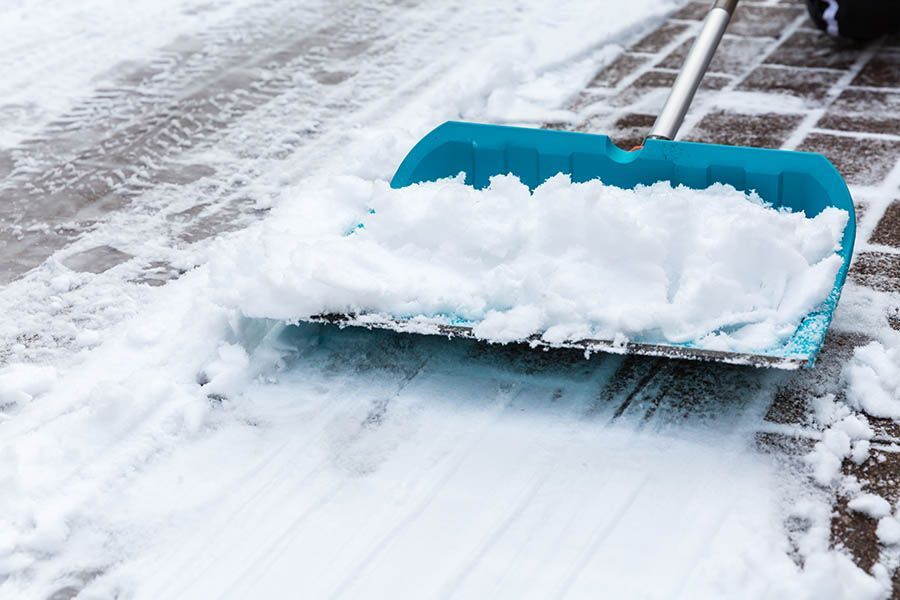 A person is shoveling snow from the sidewalk.