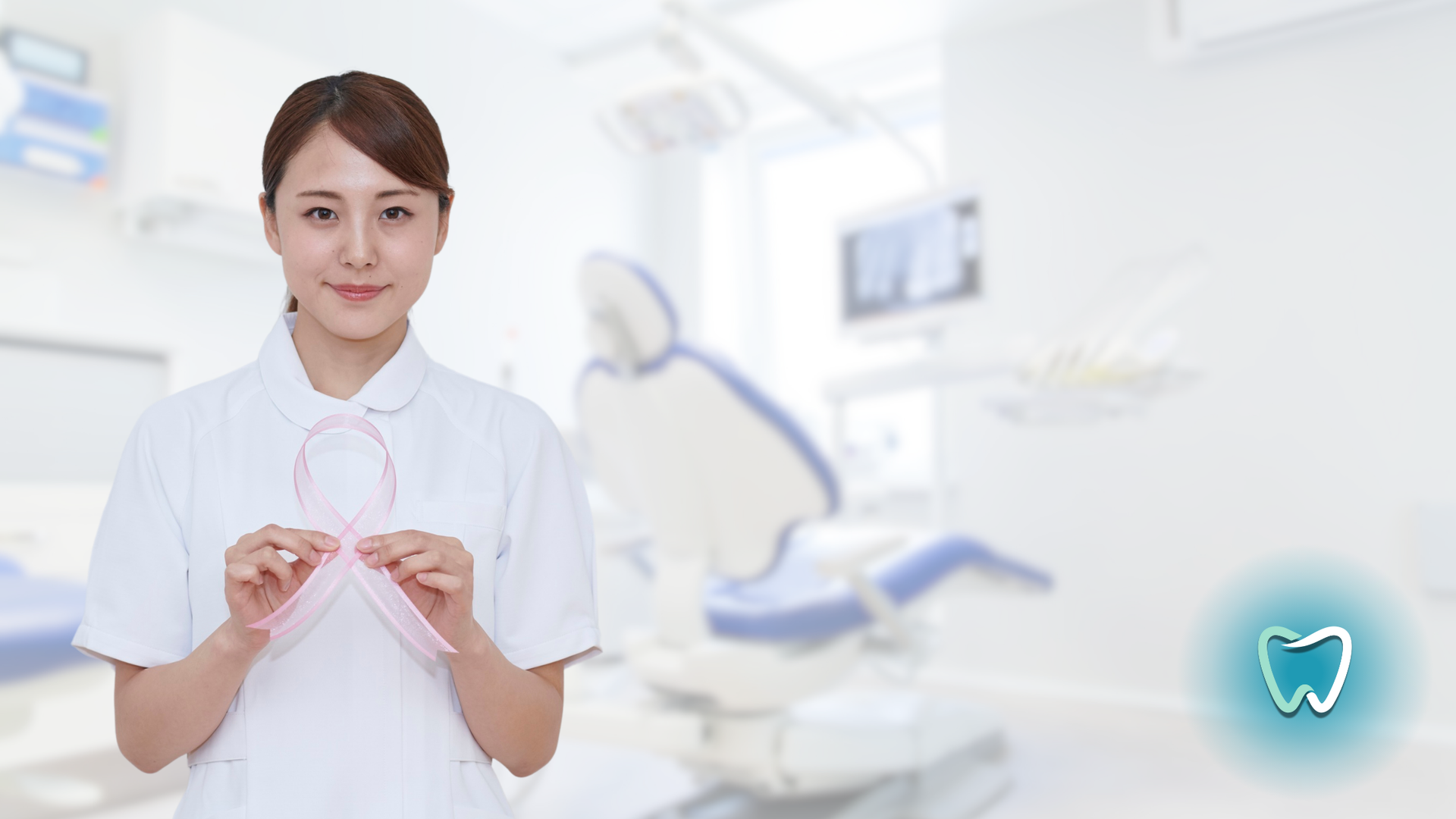 A nurse is holding a pink ribbon in a dental office.