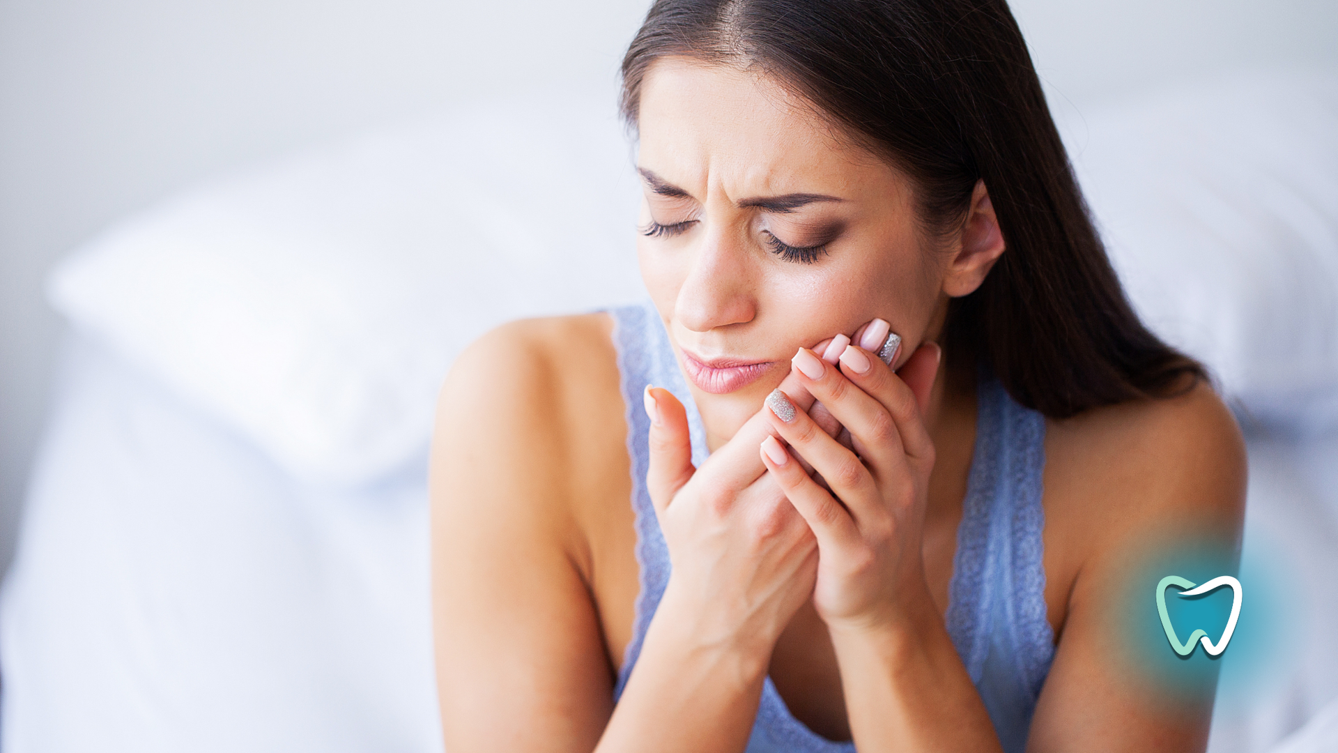 Woman with a pained expression, holding her jaw, possibly experiencing toothache.
