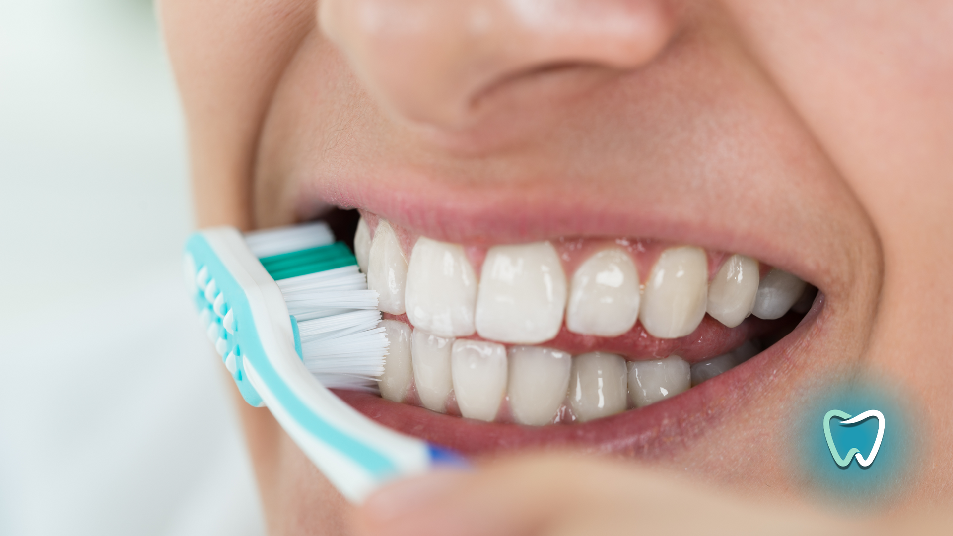A close up of a person brushing their teeth with a toothbrush.