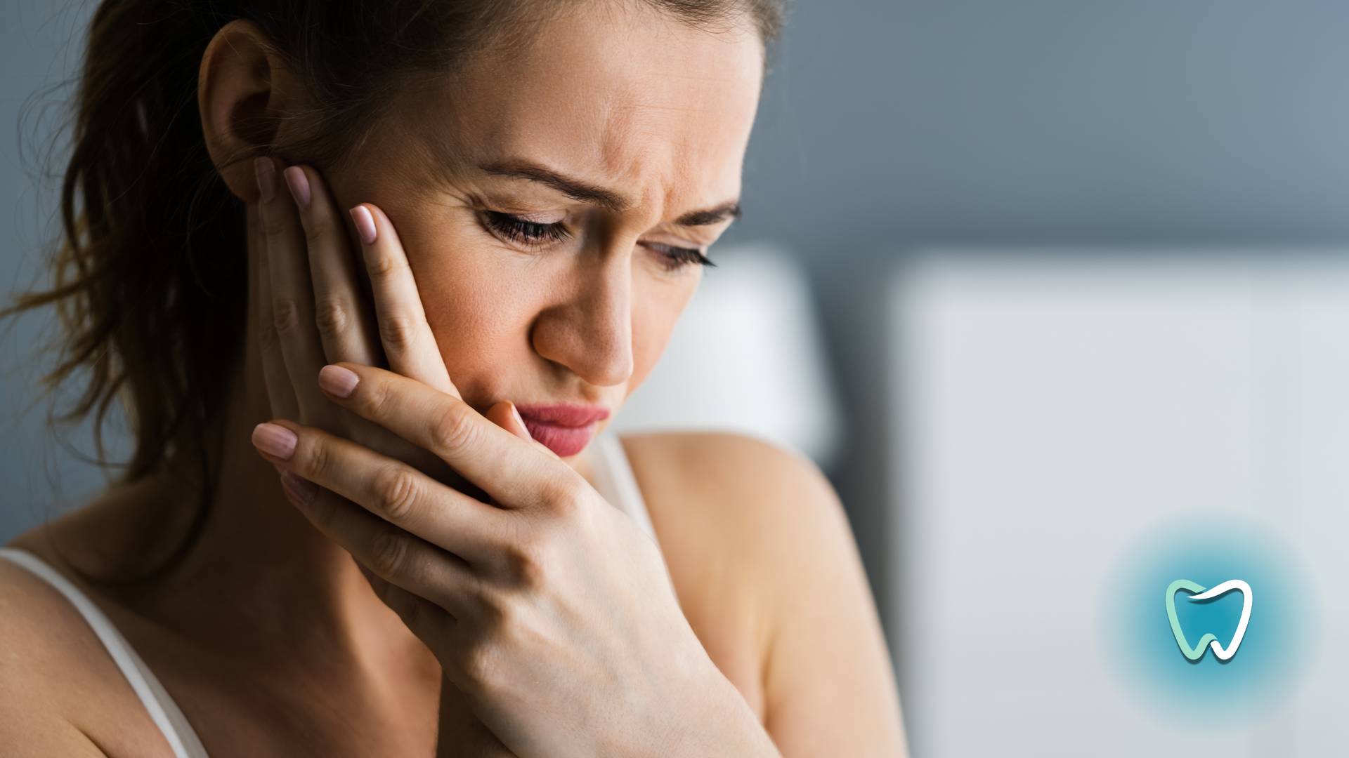 A woman is holding her face in pain because of a toothache.