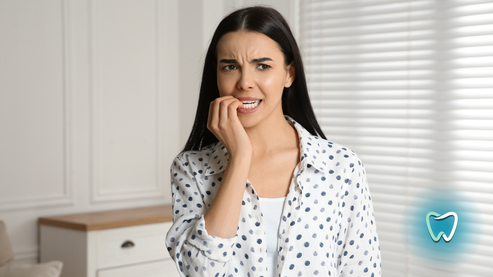 A woman is biting her nails because she has a toothache.