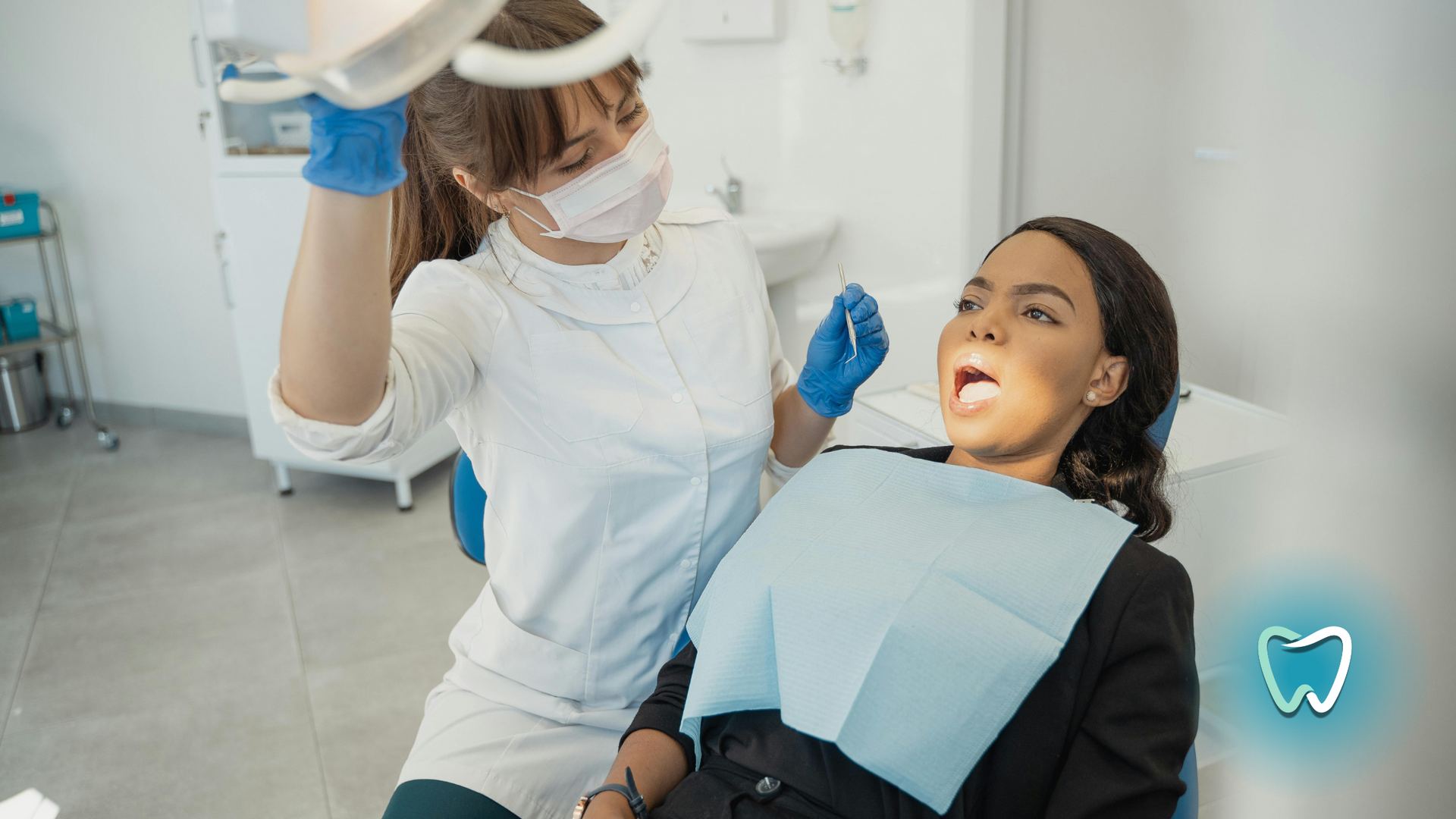 A woman is sitting in a dental chair while a dentist examines her teeth.