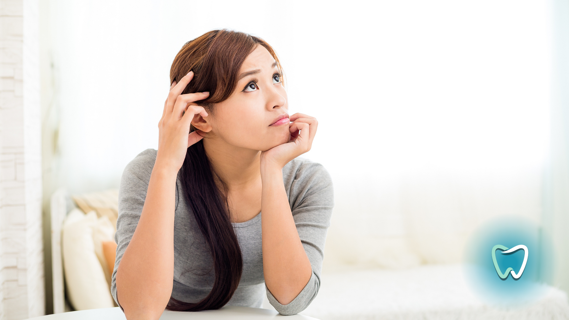 A woman is sitting on a couch looking up at the sky.