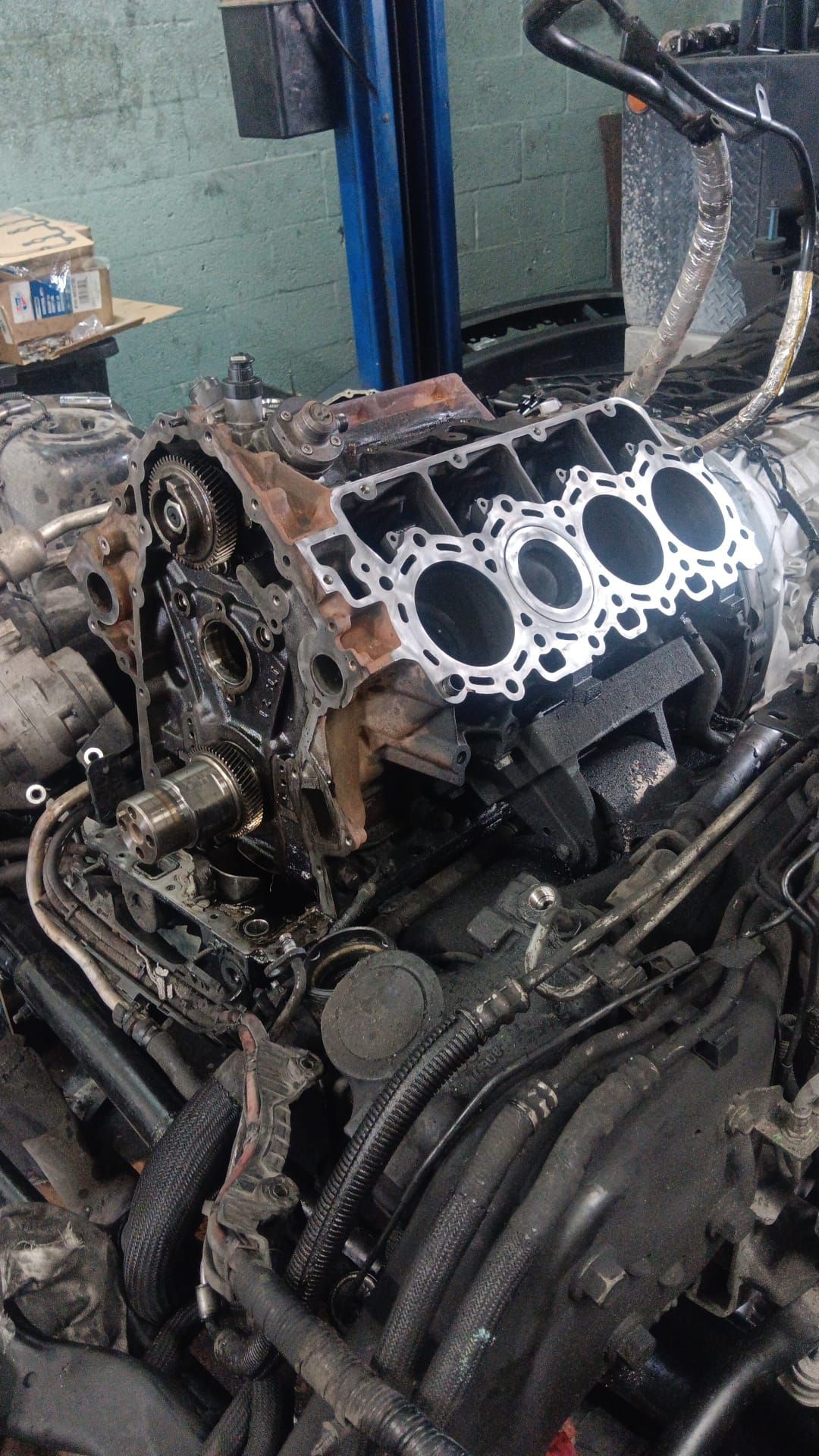 A close up of a car engine being worked on in a garage.