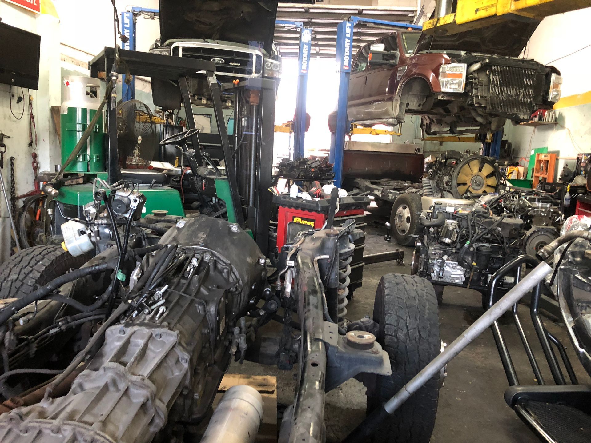 A garage filled with lots of engines and parts.