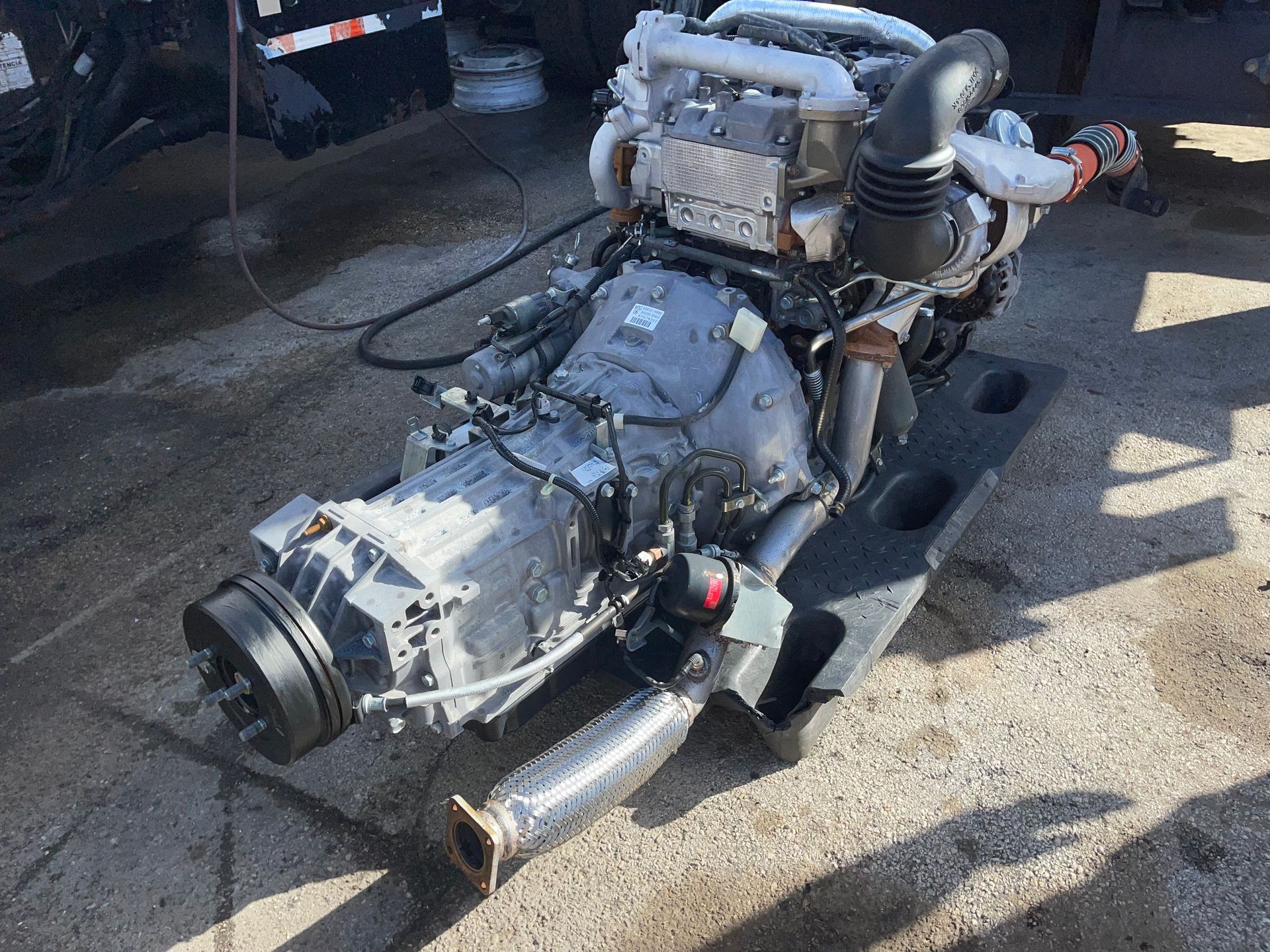 A diesel engine is sitting on the ground next to a truck.