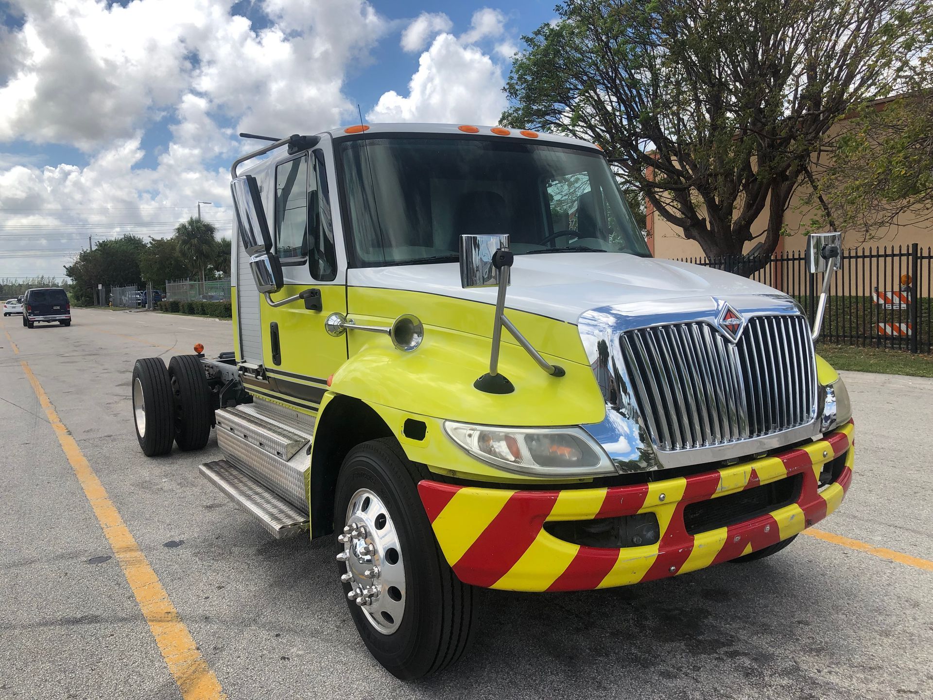 A yellow and red tow truck is parked in a parking lot.