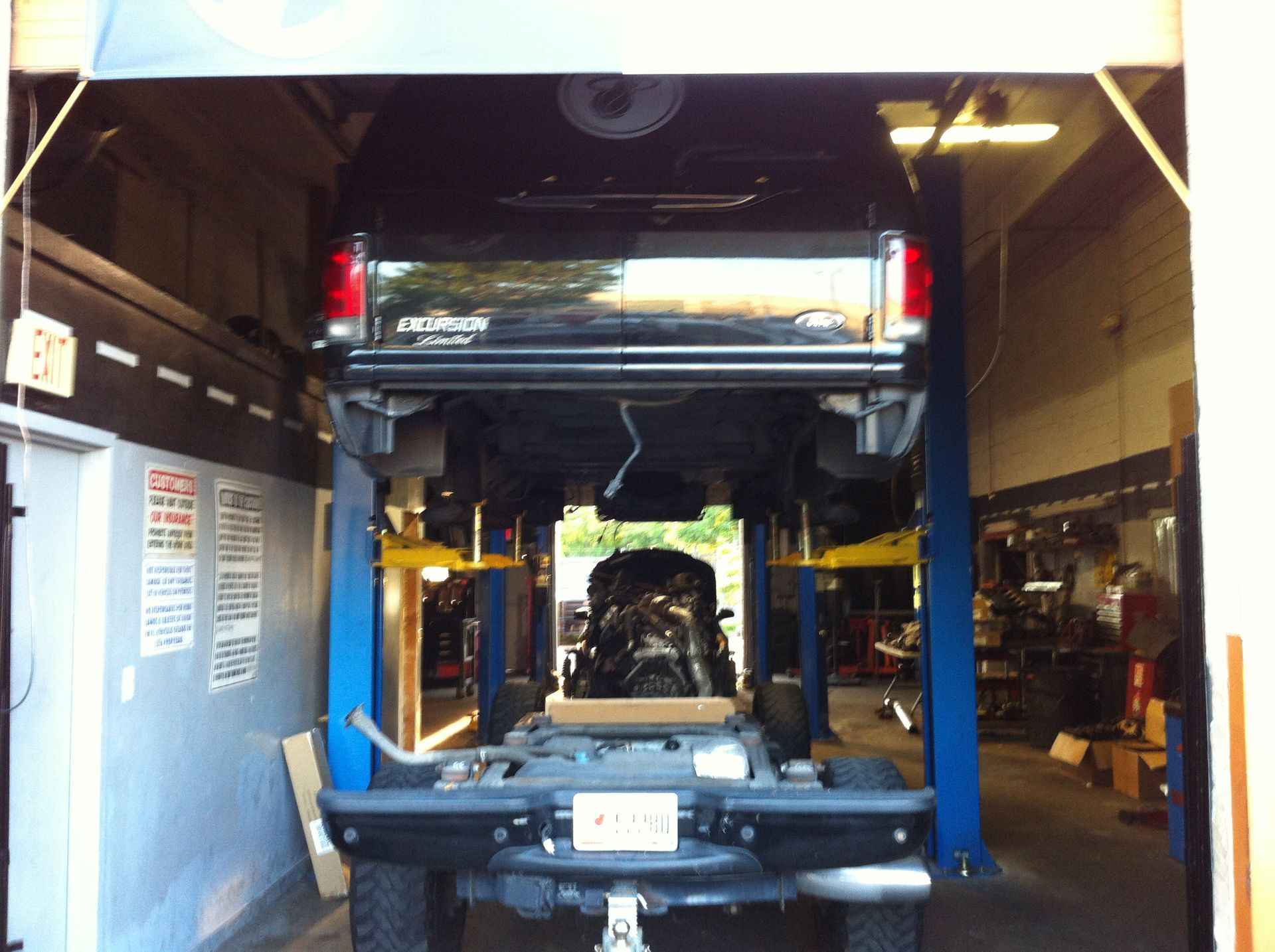 A truck is sitting on a lift in a garage